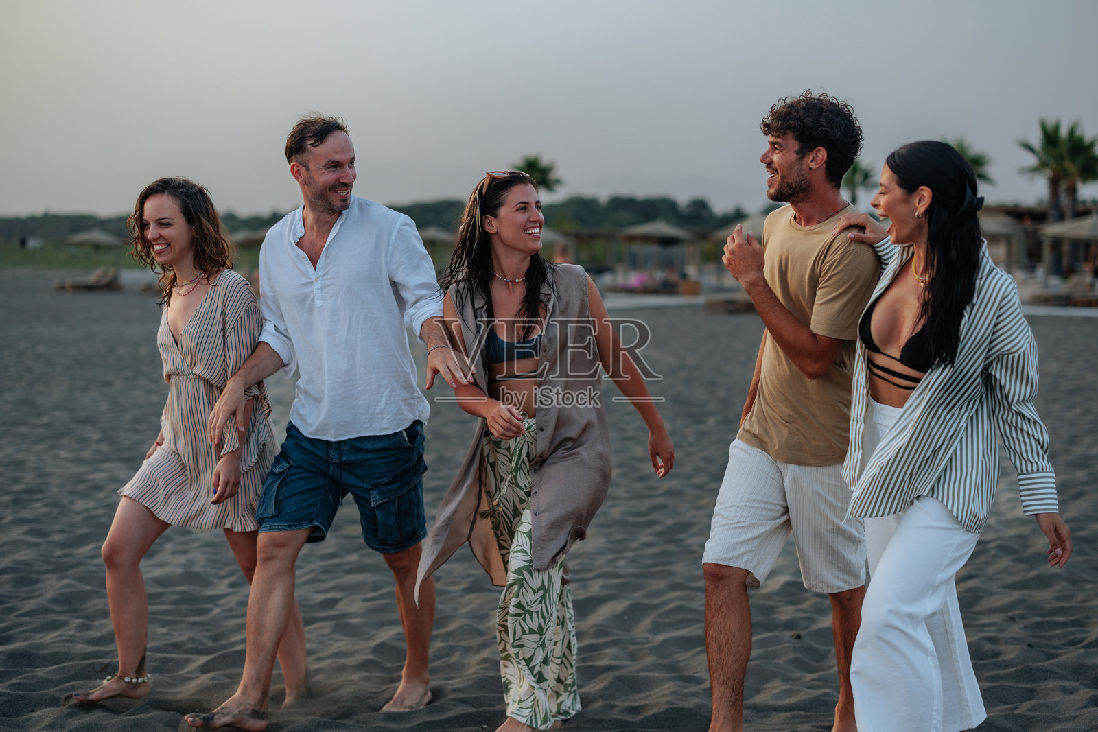 一群多元化的朋友在沙滩上散步照片摄影图片