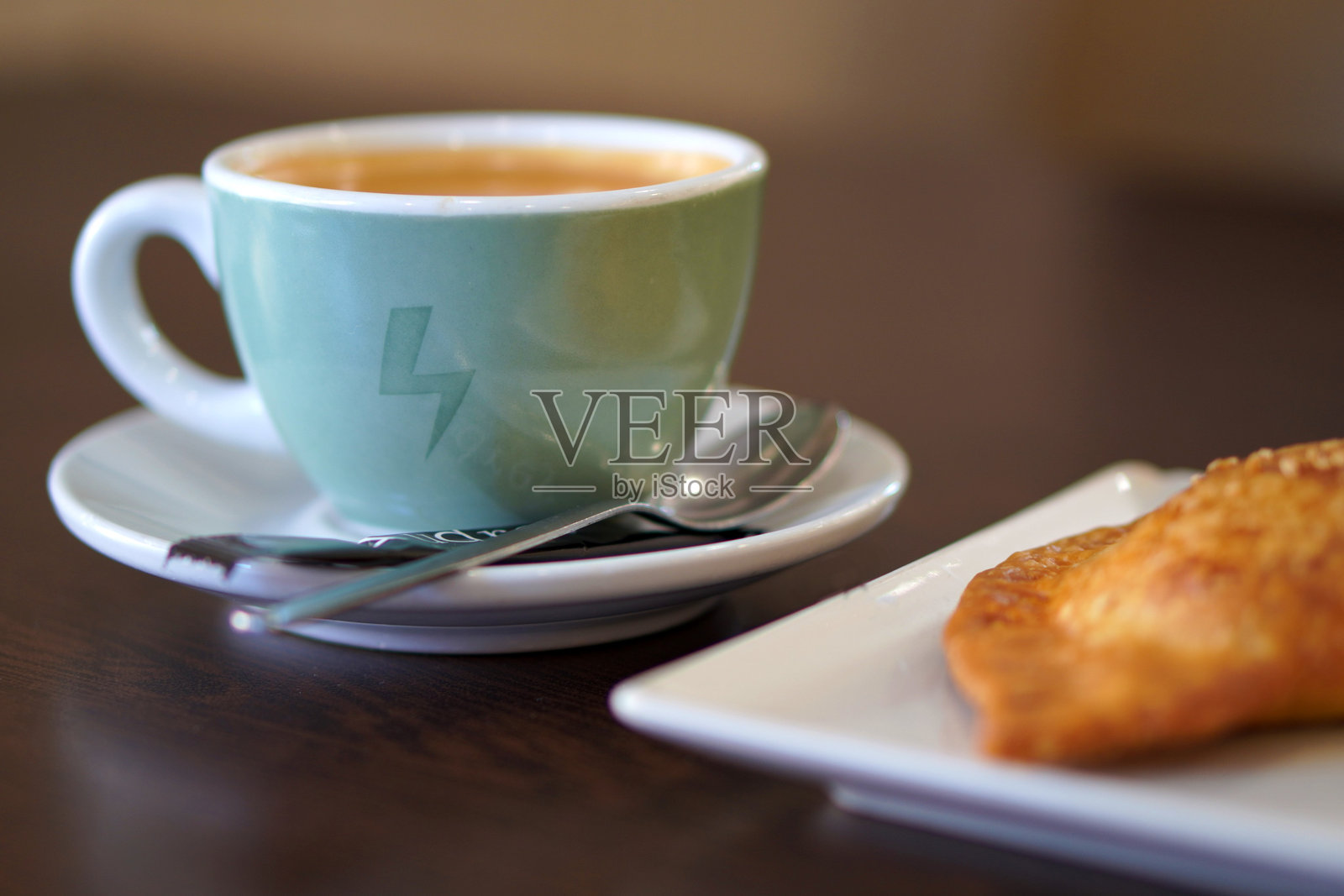 咖啡店桌子上的牛奶咖啡和一个松饼照片摄影图片