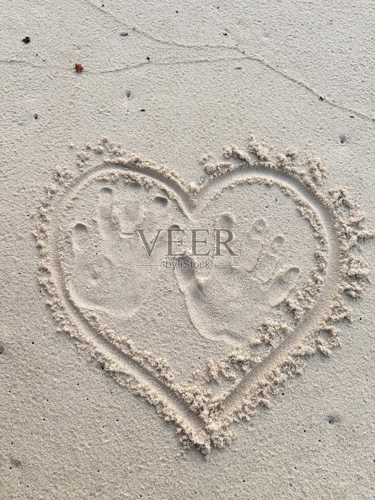 马尔代夫岛度假村沙滩上蜜月情侣的手印心形图案照片摄影图片