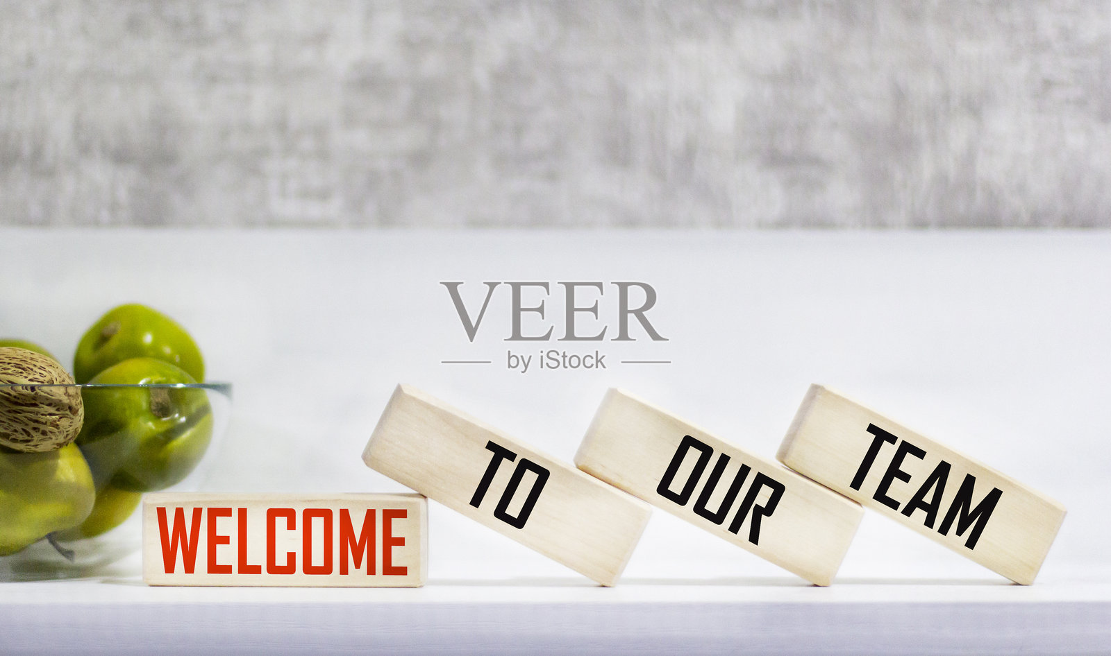 “欢迎加入我们的团队”符号。概念词“欢迎加入我们的团队”在美丽的桌面背景上的木块上。照片摄影图片