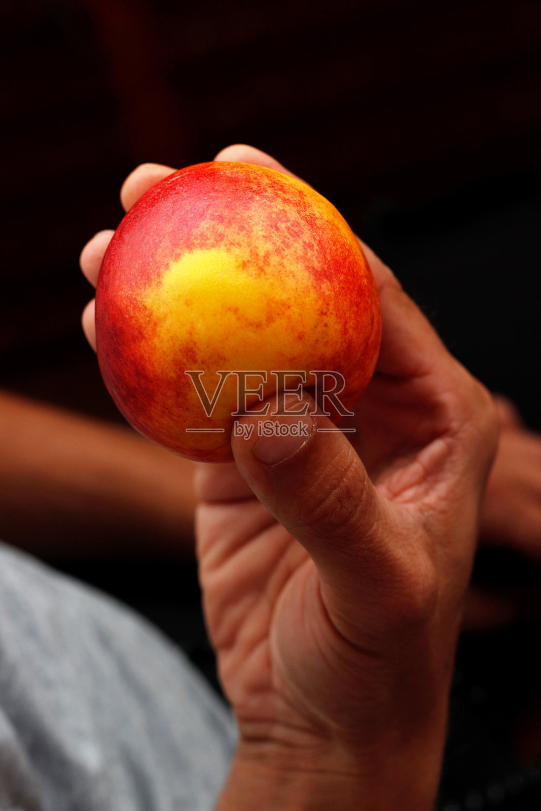 手中握着桃子，男人手里拿着桃子照片摄影图片