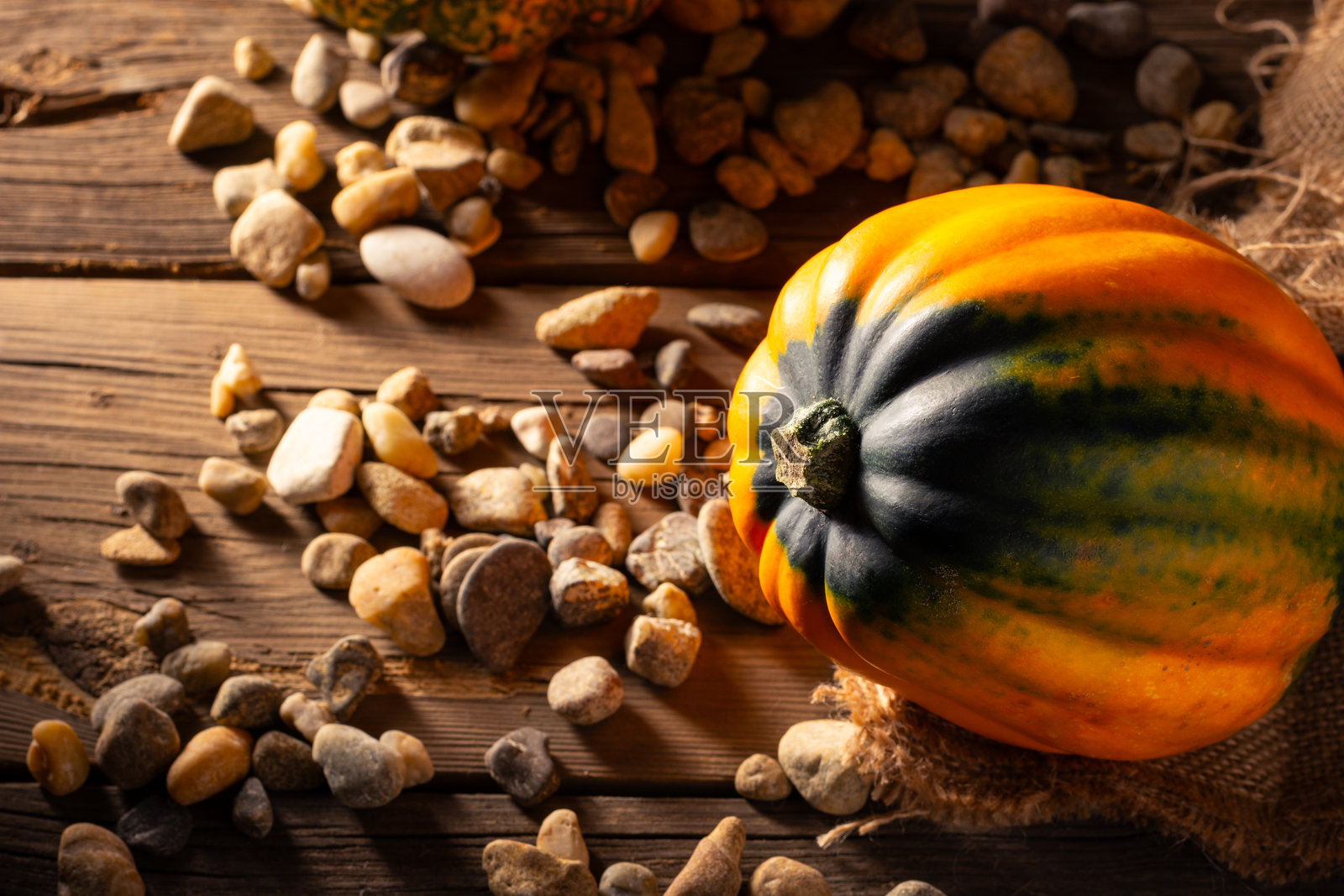 南瓜特写，放在麻袋上，置于古朴的木桌上。照片摄影图片
