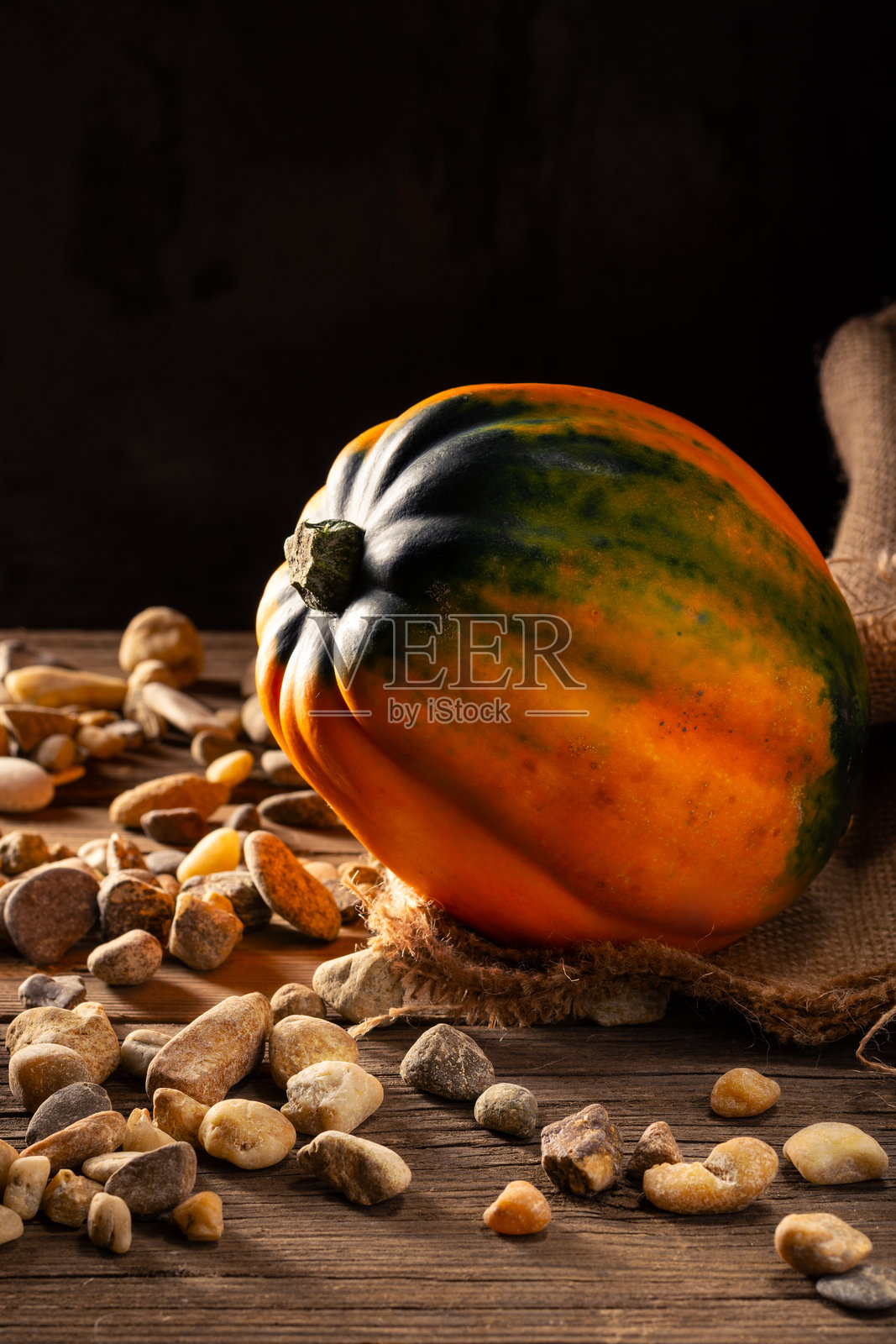 南瓜放在一个麻袋上，麻袋放在一个乡村风格的木桌上。照片摄影图片