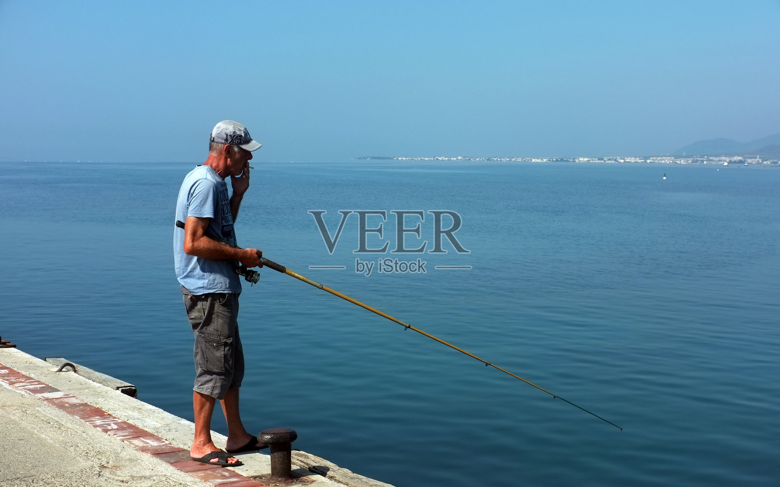 老人用钓竿钓鱼照片摄影图片