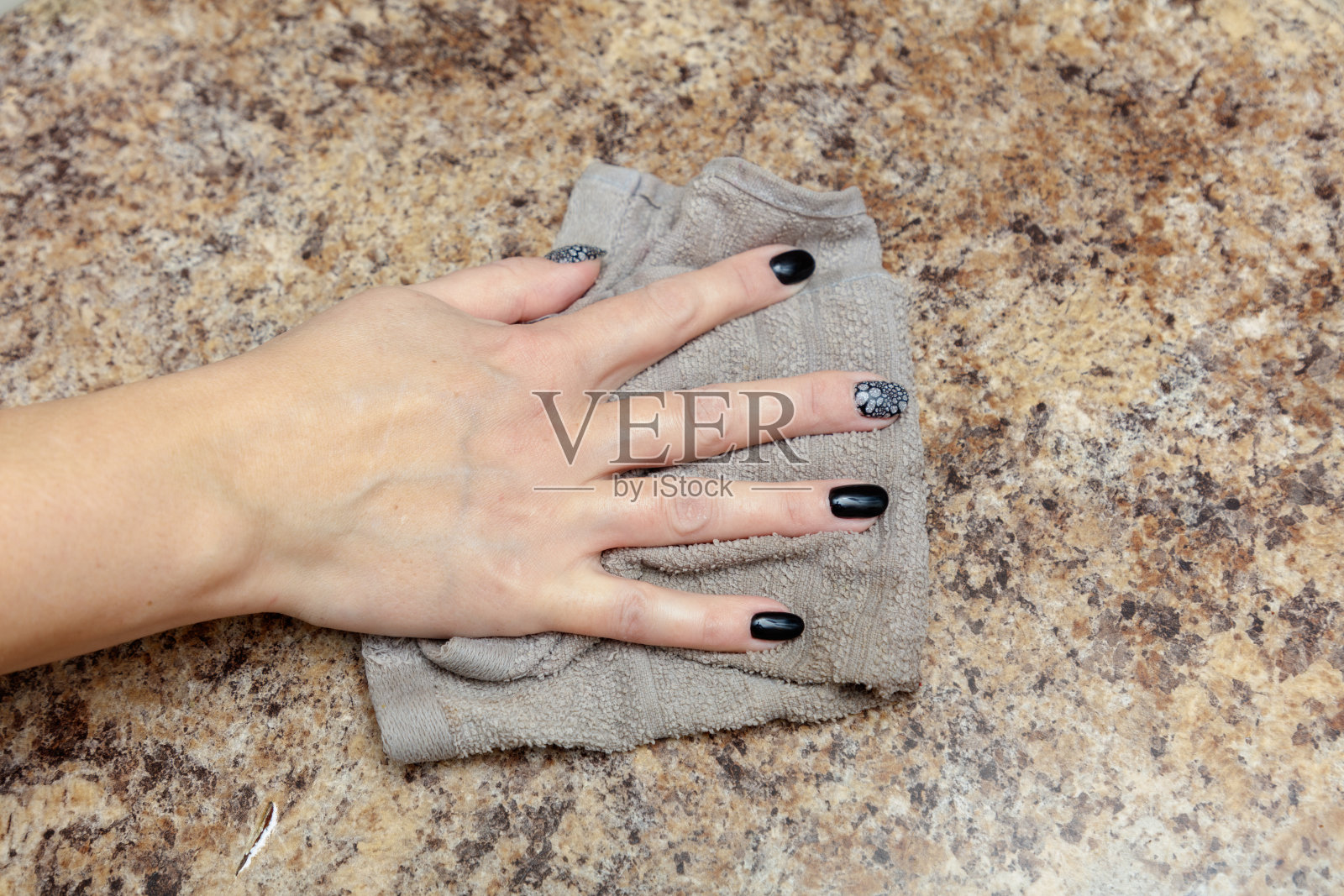 一只手正在用毛巾擦拭台面照片摄影图片