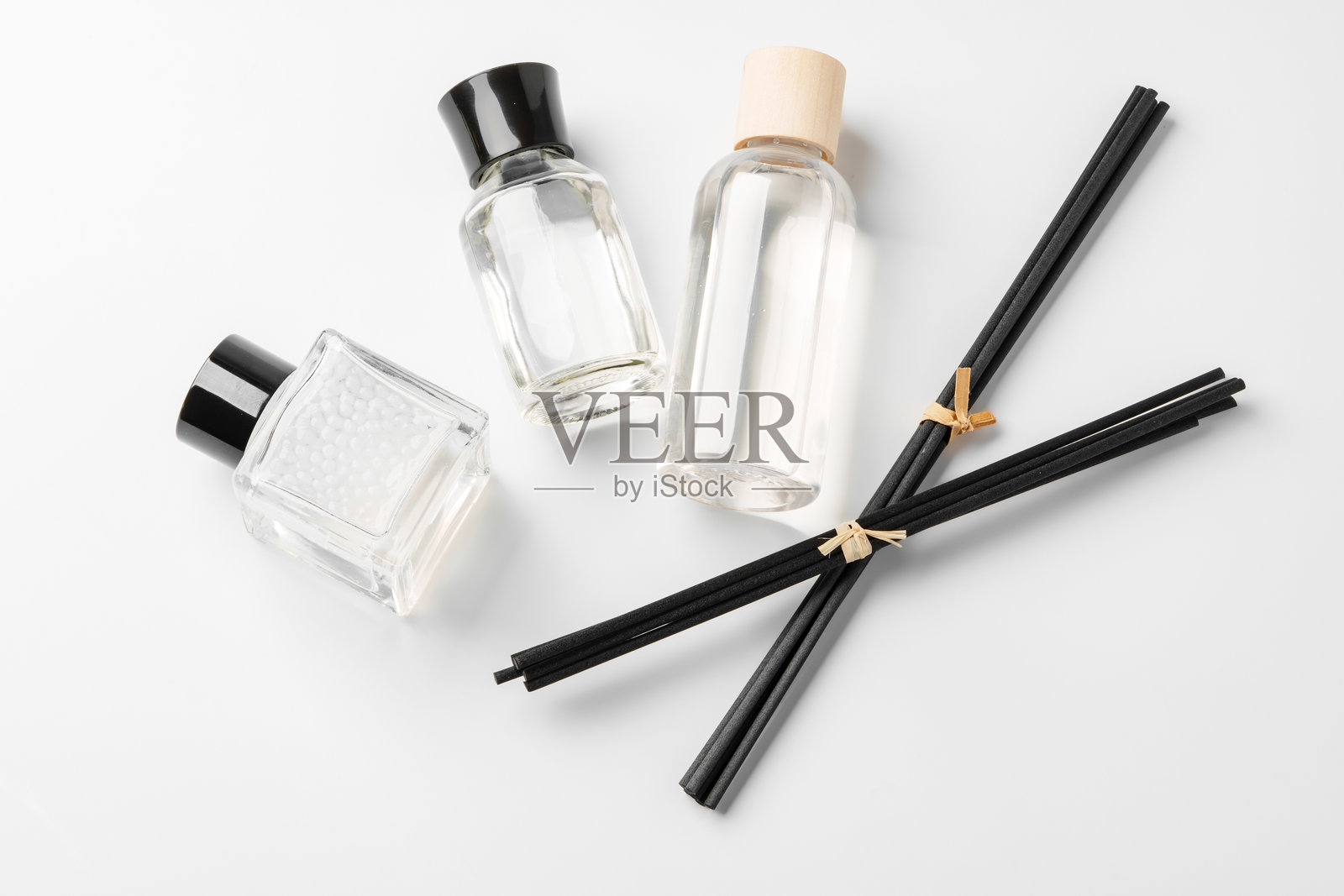 优雅的精油扩散器与香薰棒和玻璃瓶在简约表面上的精致摆放照片摄影图片