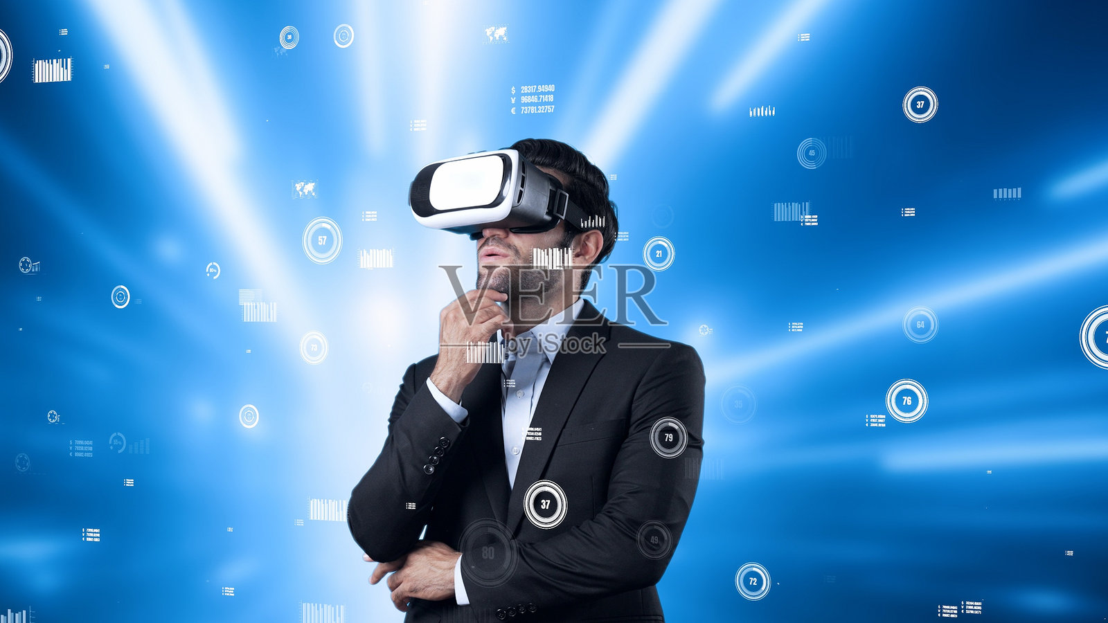 商人注视着浮动的财务图表并做出决策。设备。照片摄影图片