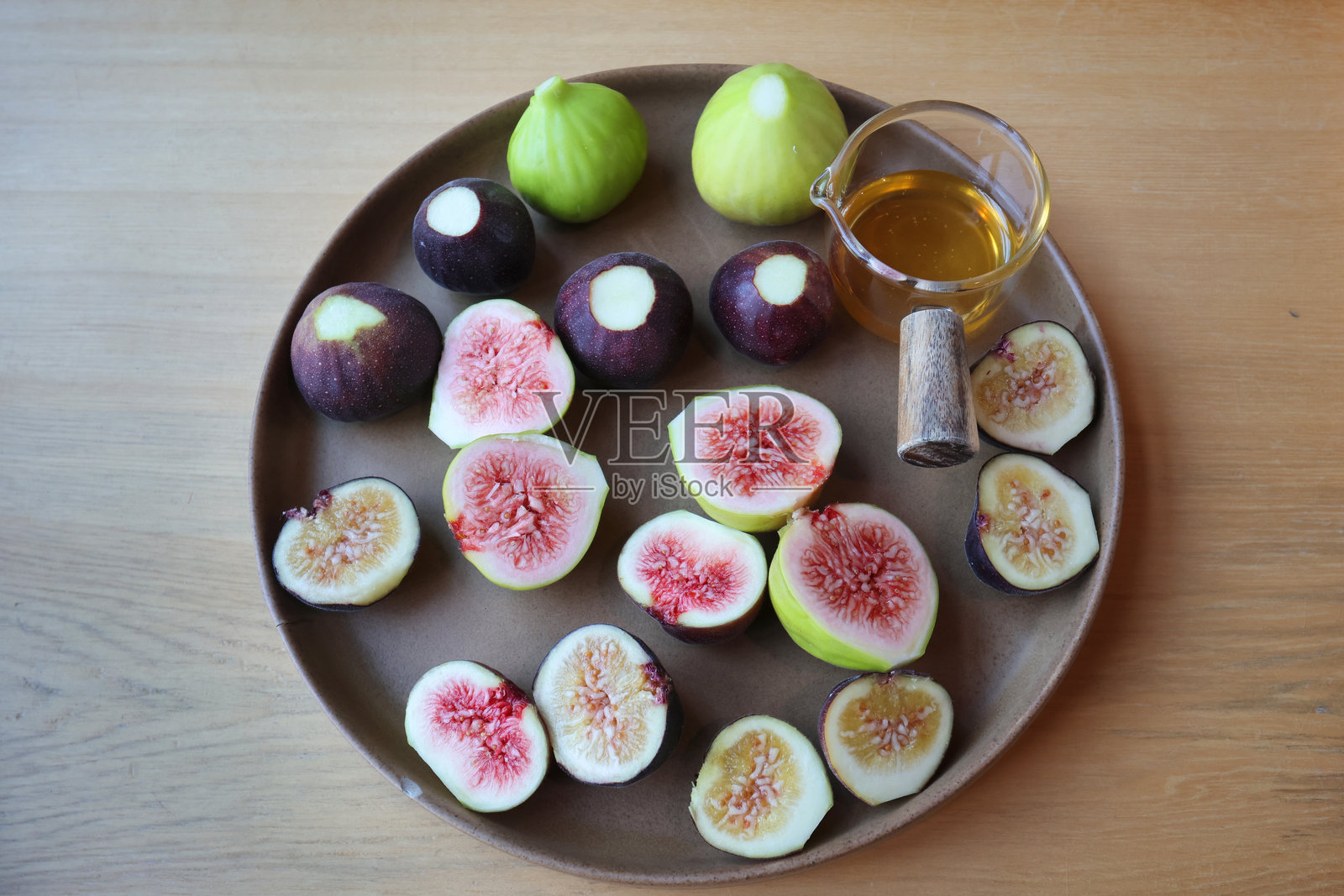 成熟的无花果与蜂蜜一起盛在盘子里照片摄影图片