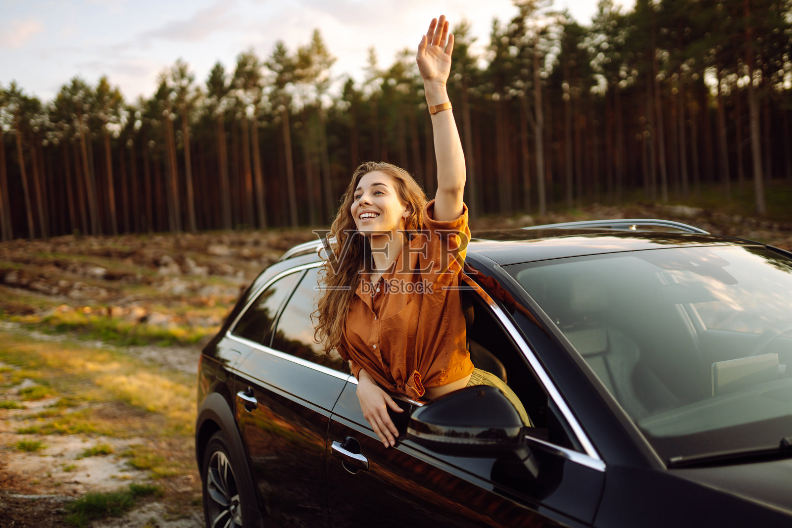 快乐的女人在车窗旁。照片摄影图片
