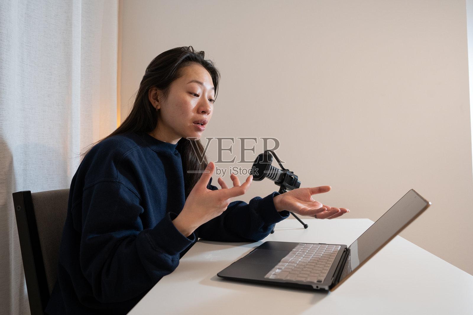 女性使用笔记本电脑和麦克风录制播客照片摄影图片
