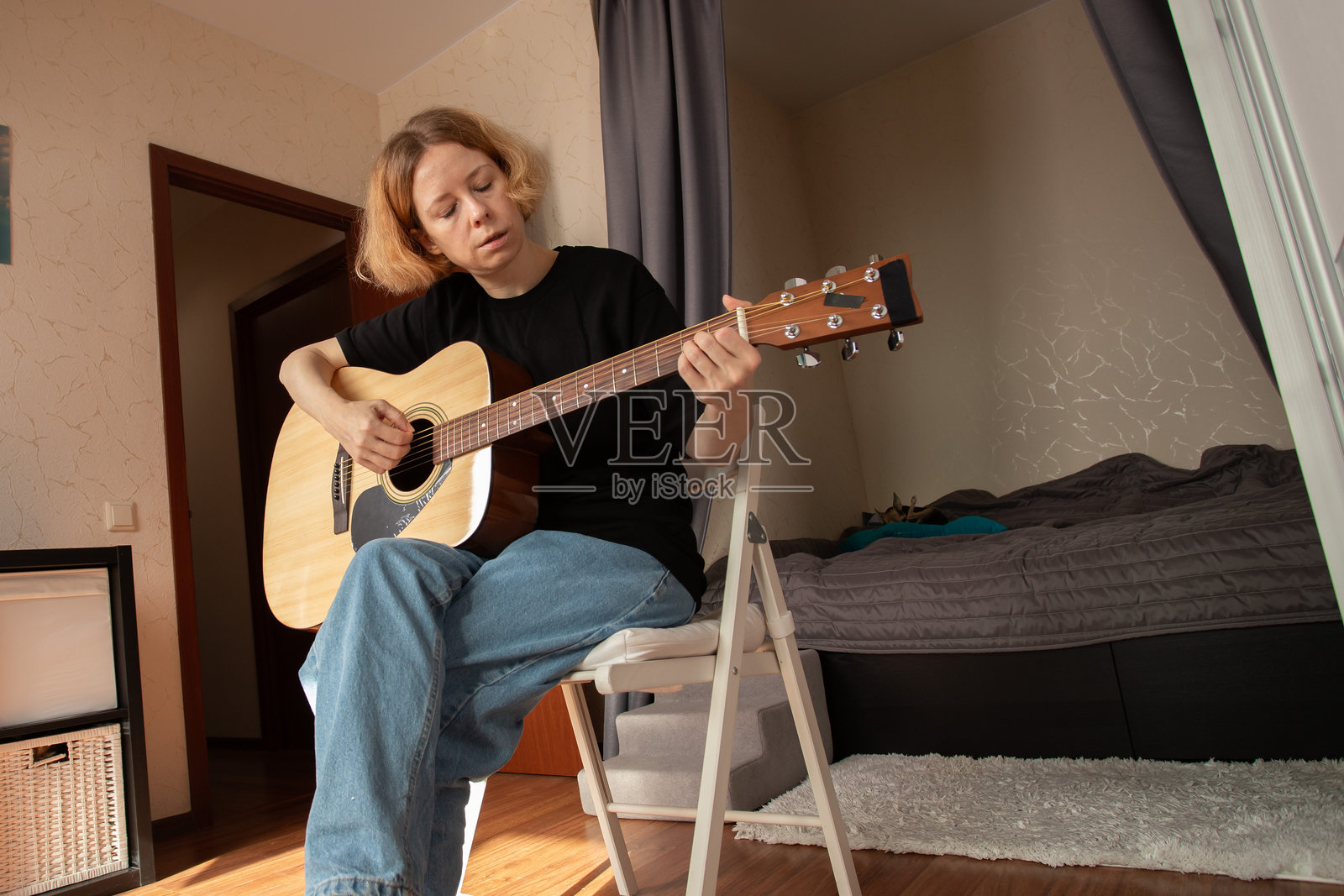 在家学习的吉他手，音乐家专注于吉他演奏和旋律，努力提升音乐技能。照片摄影图片
