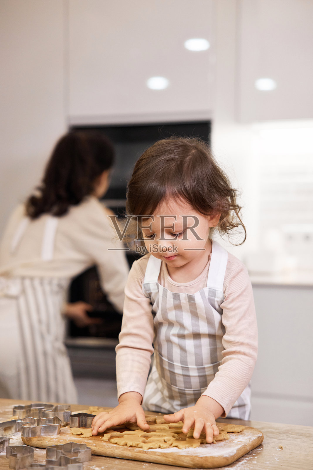 可爱的小女孩穿着围裙在烤饼干照片摄影图片