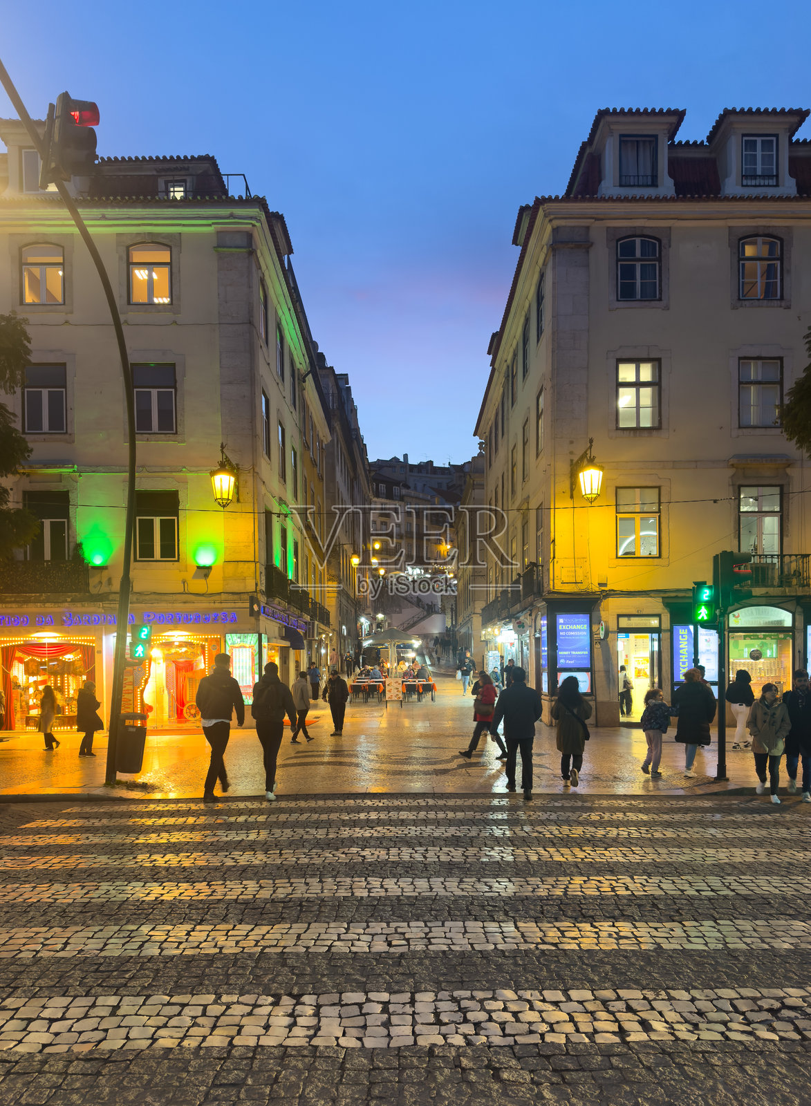 里斯本葡萄牙老城区广场的傍晚景色,游人和路人穿梭其间。照片摄影图片