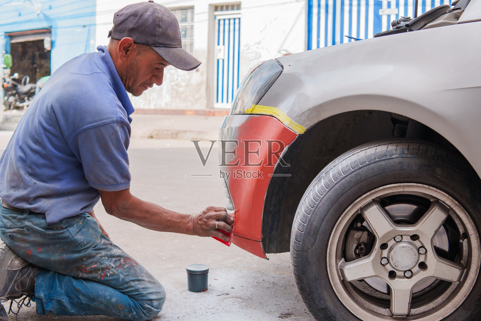 一名机械师正在修理汽车的保险杠照片摄影图片