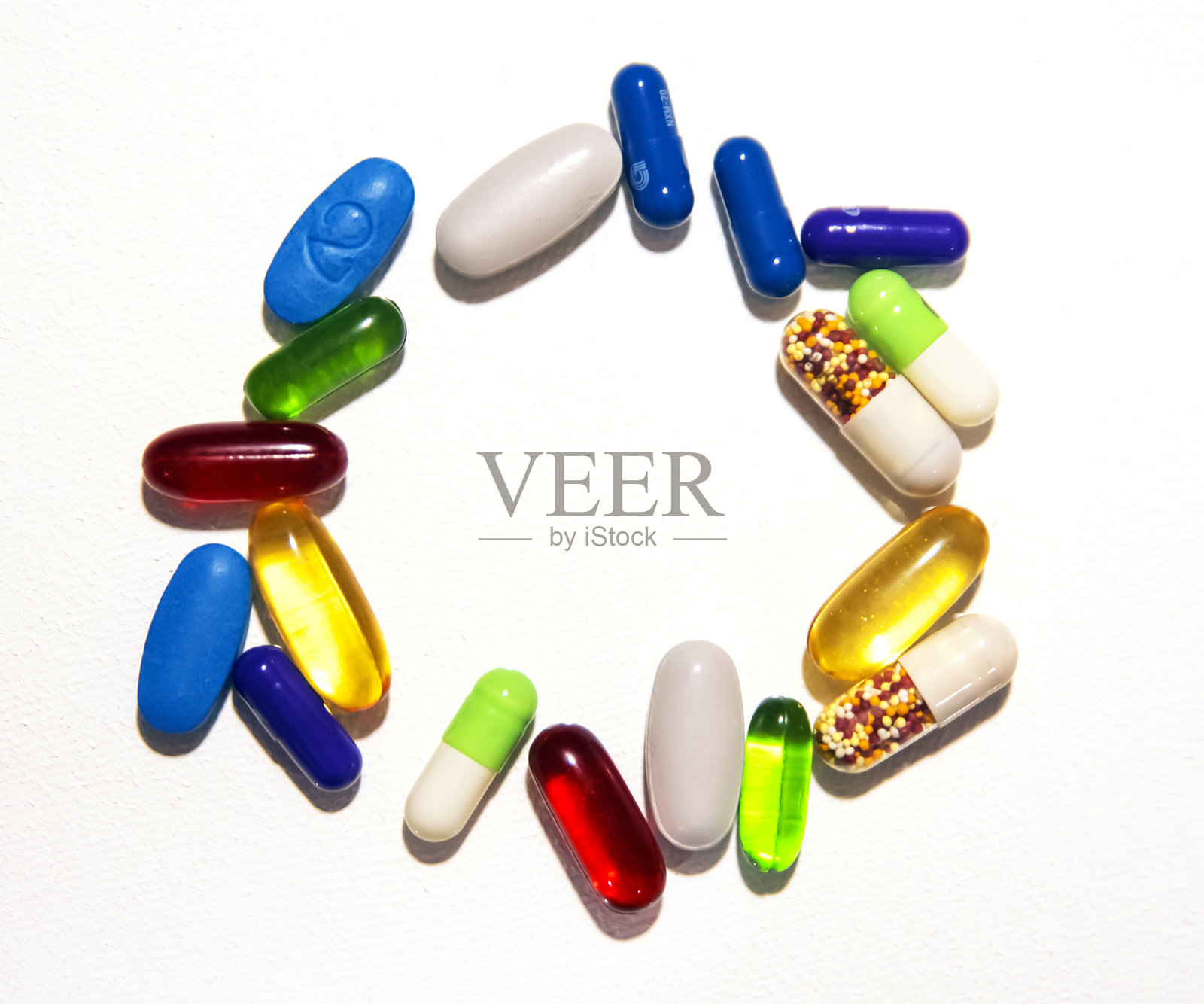 维生素补充剂在圆圈中，中央留有白色空白，背景为多彩的药片和药物照片摄影图片