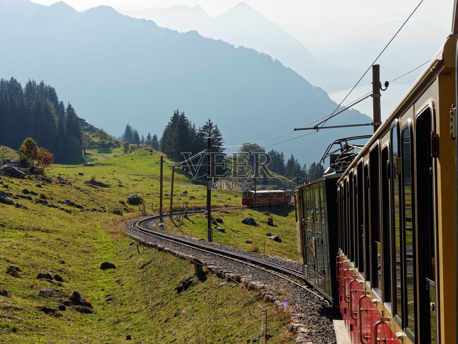 瑞士阿尔卑斯山脉中，火车穿越山谷的美丽景色。照片摄影图片