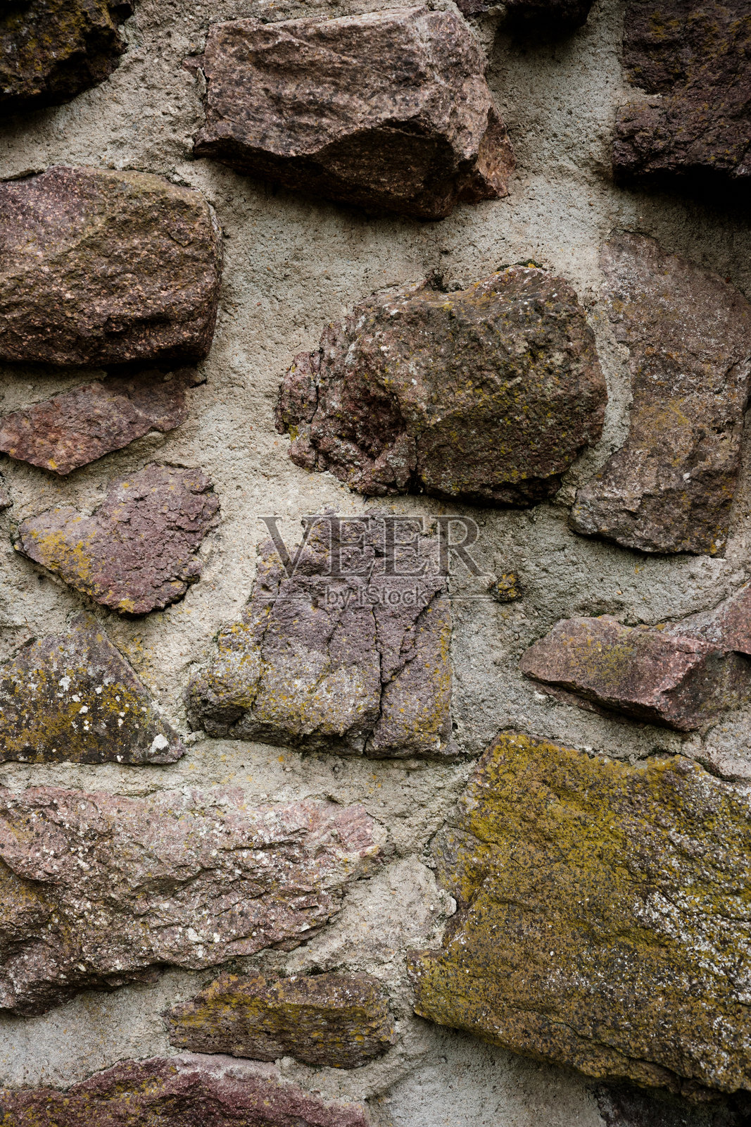 一面由粗糙质感的石头构成的墙壁，墙壁呈棕色和白色。照片摄影图片