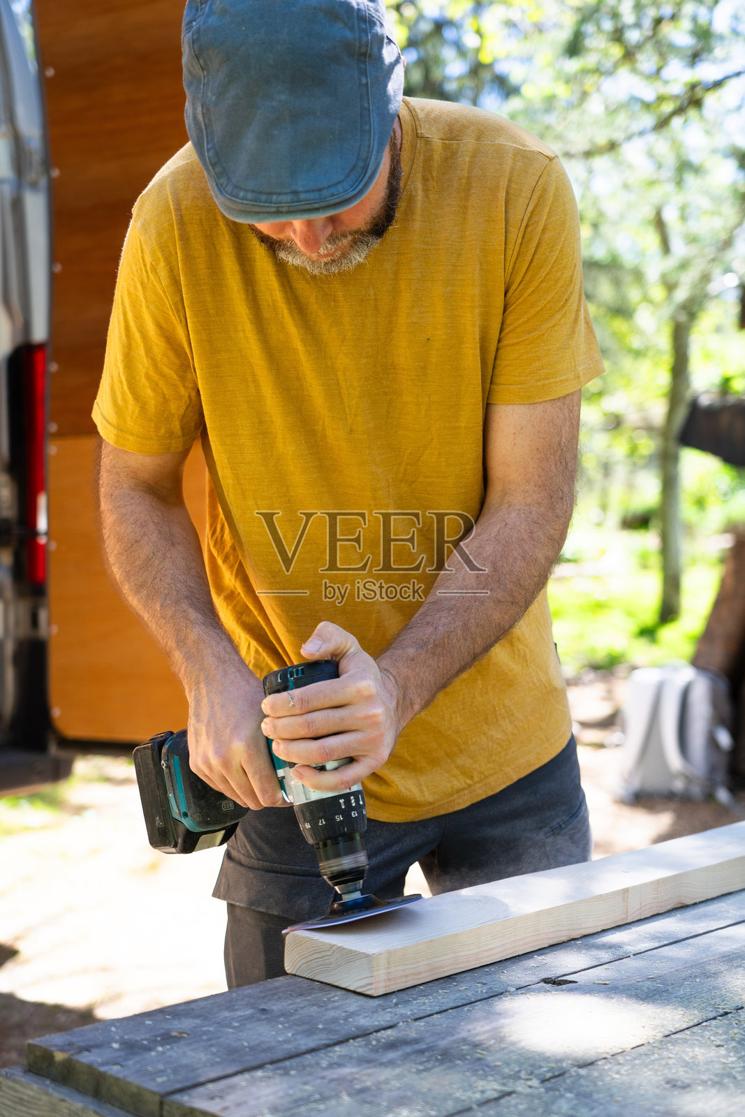 木匠在户外使用无绳电钻的轨道砂光机附件进行木工项目照片摄影图片