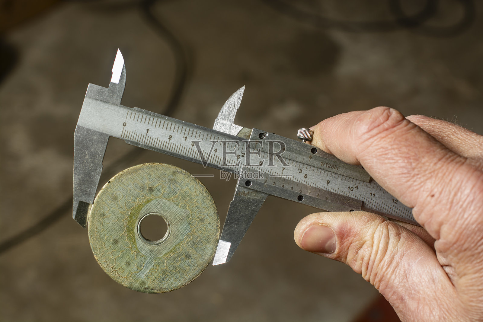 使用卡尺测量金属垫圈的直径。照片摄影图片