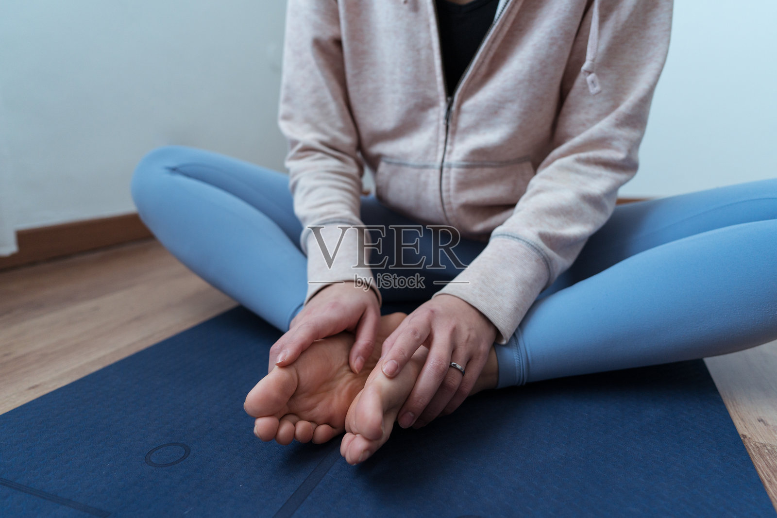 在蓝色瑜伽垫上坐姿的瑜伽练习者照片摄影图片