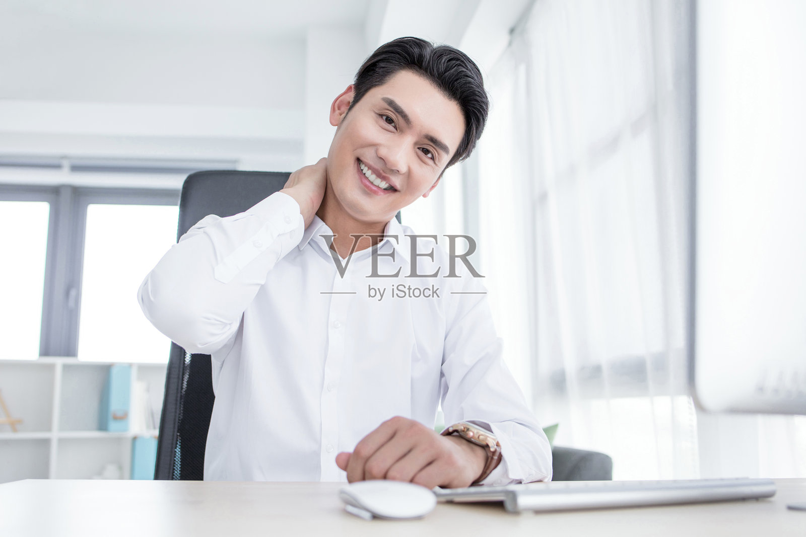 孤独的白色背景上，面临颈部疼痛的帅气男士肖像，显得压力重重。照片摄影图片