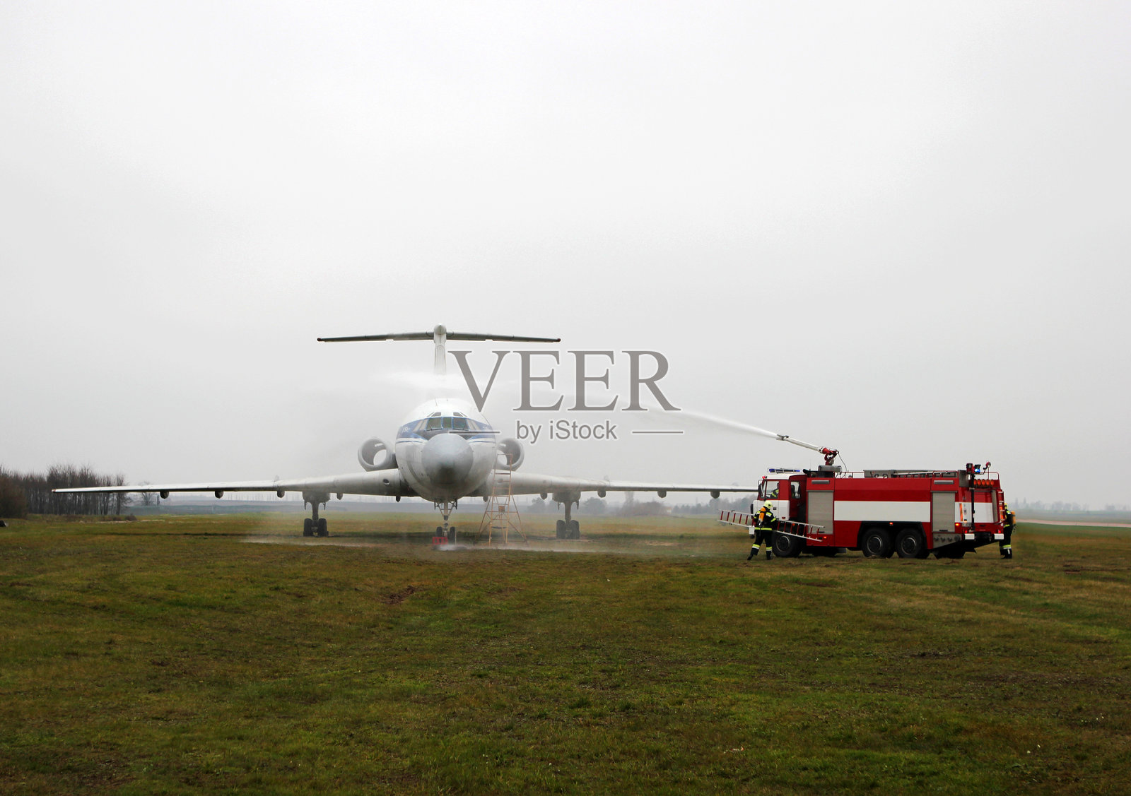 消防车在机场为飞机喷洒水。照片摄影图片