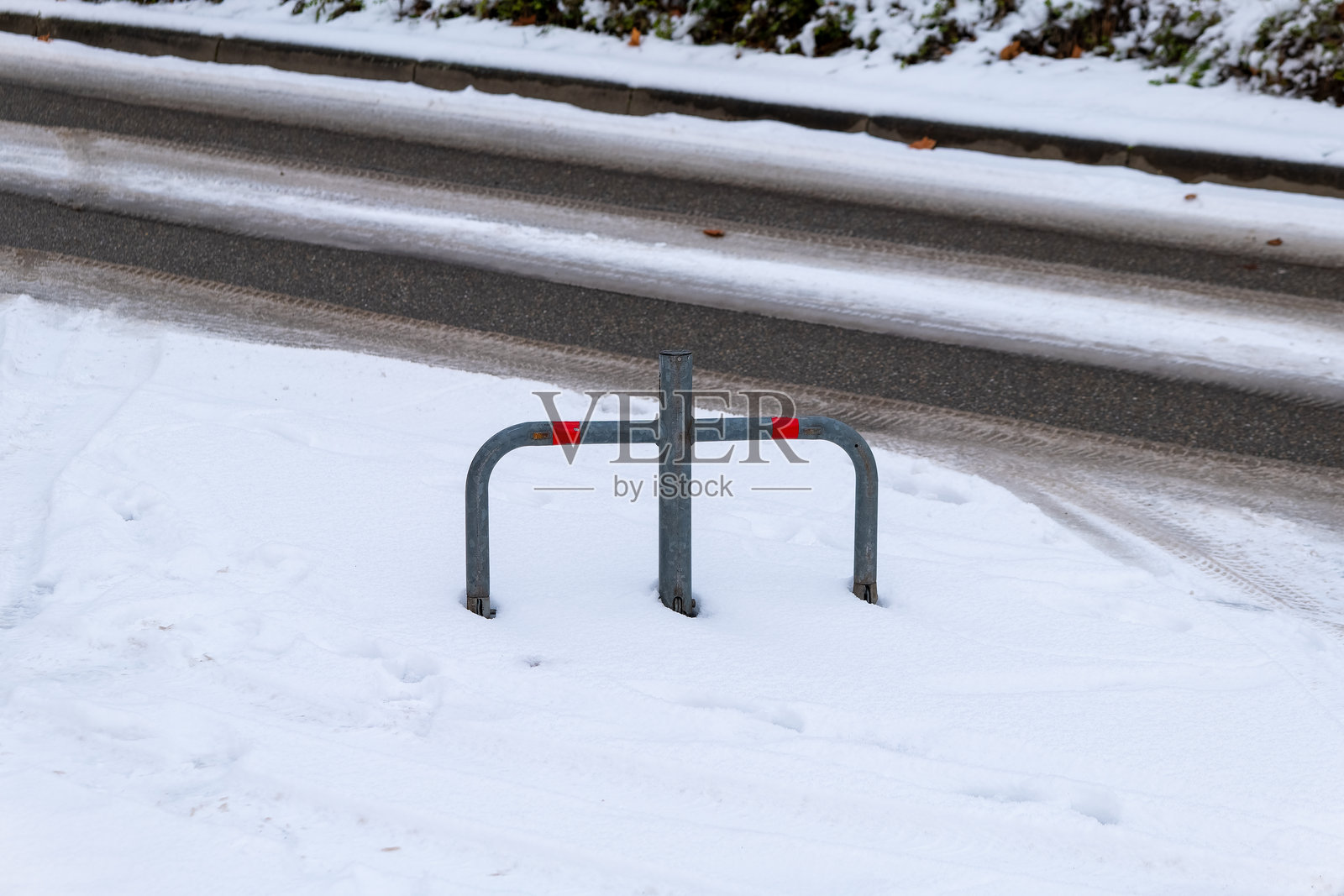 城市冬日路边部分埋在雪中的自行车架照片摄影图片