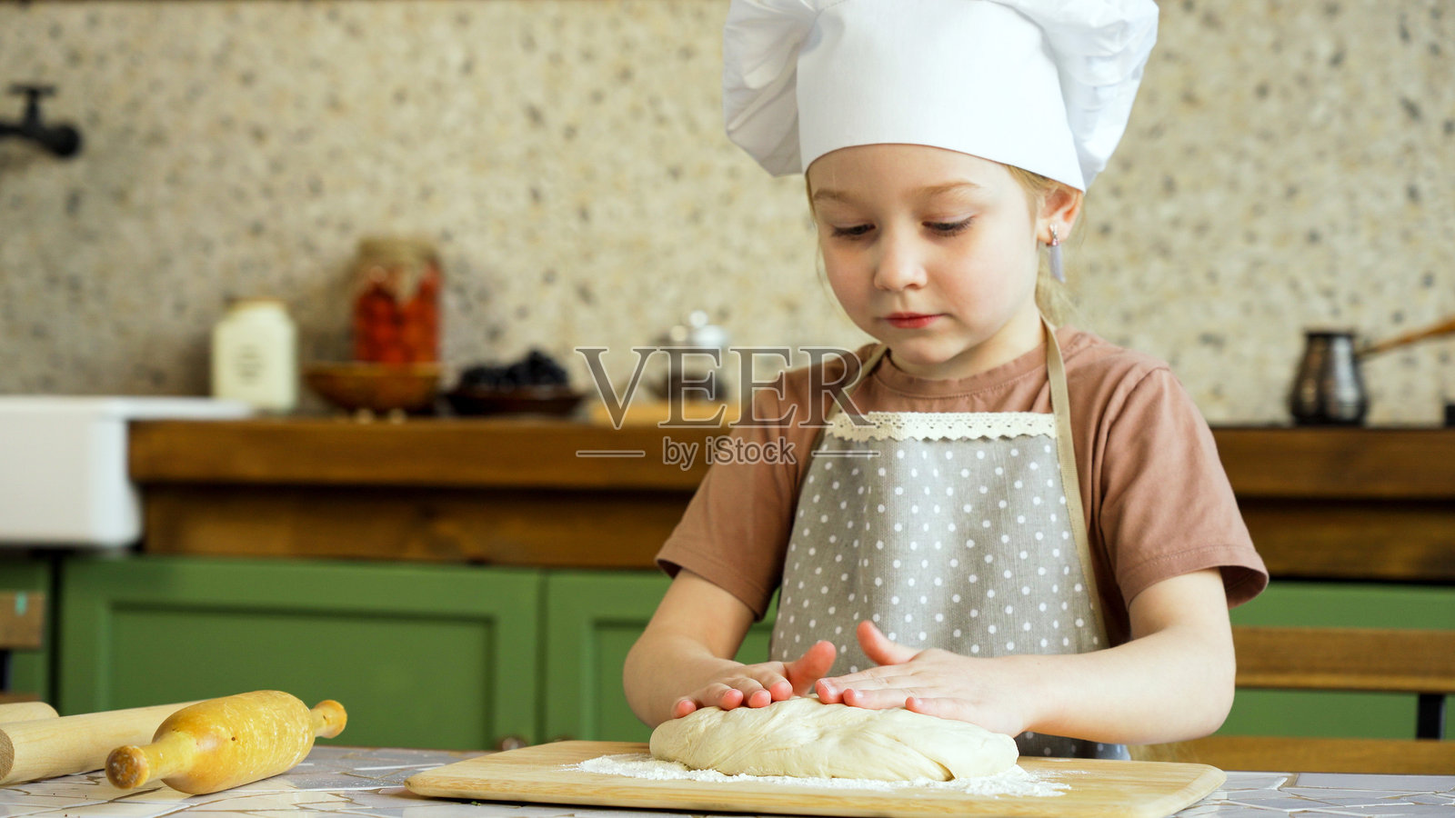 小面包师在厨房里制作面团照片摄影图片