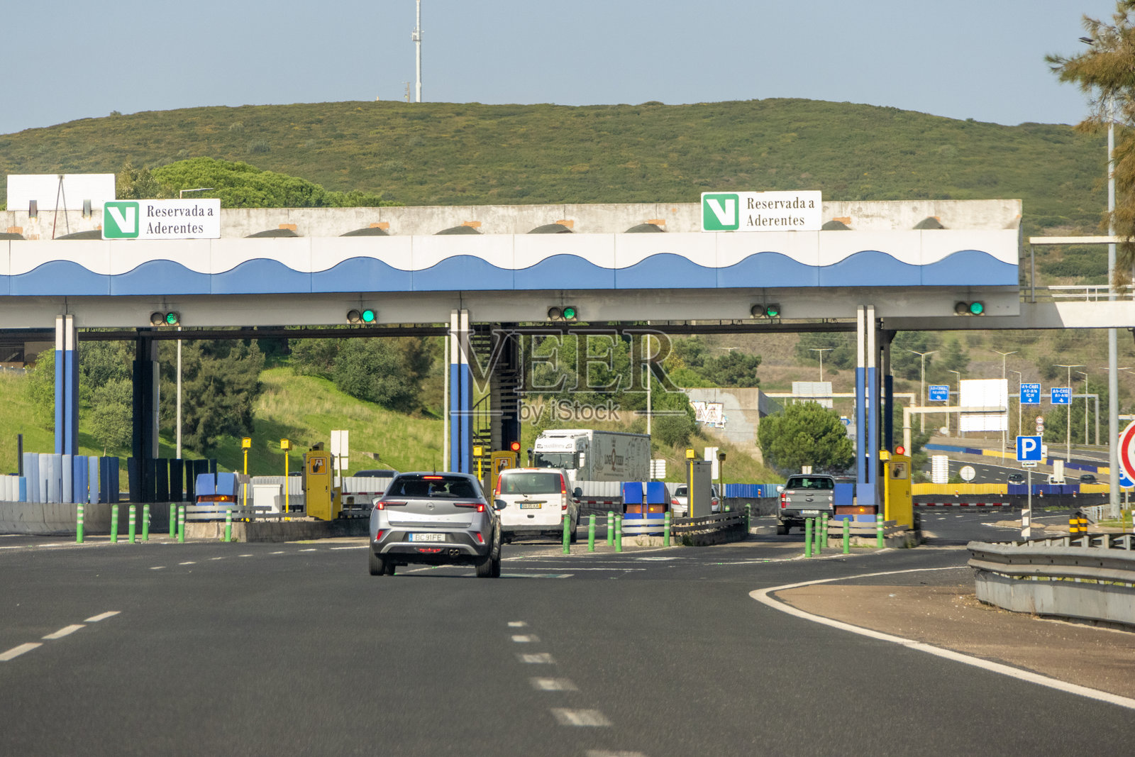 阳光明媚的日子里，汽车经过收费站照片摄影图片