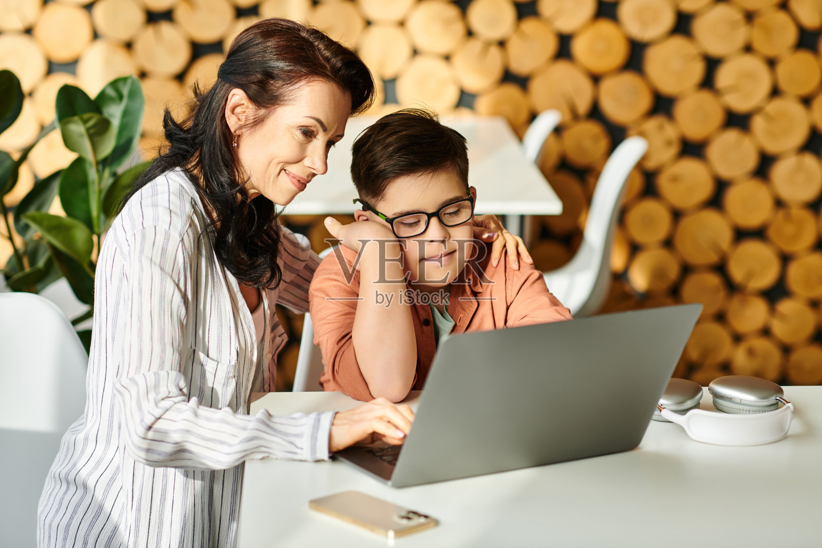 慈爱的母亲在咖啡馆陪伴支持她的唐氏综合症儿子照片摄影图片