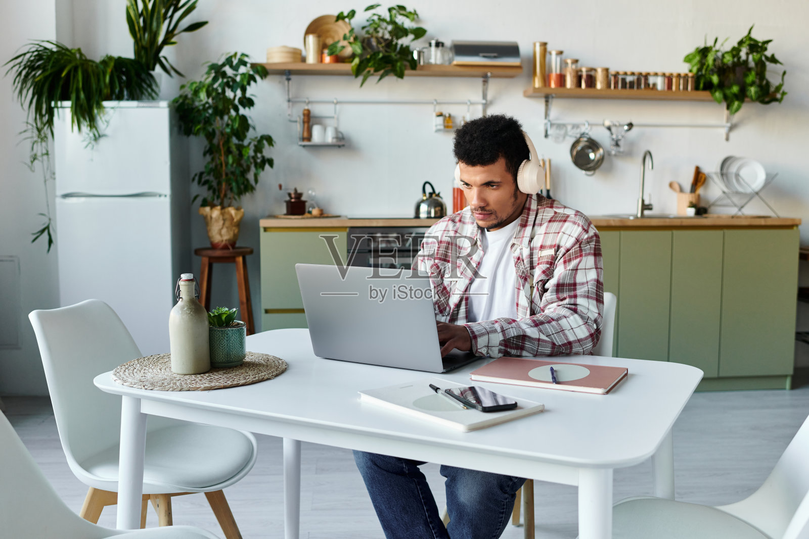 卷发年轻男子在时尚现代公寓环境中专注于工作照片摄影图片