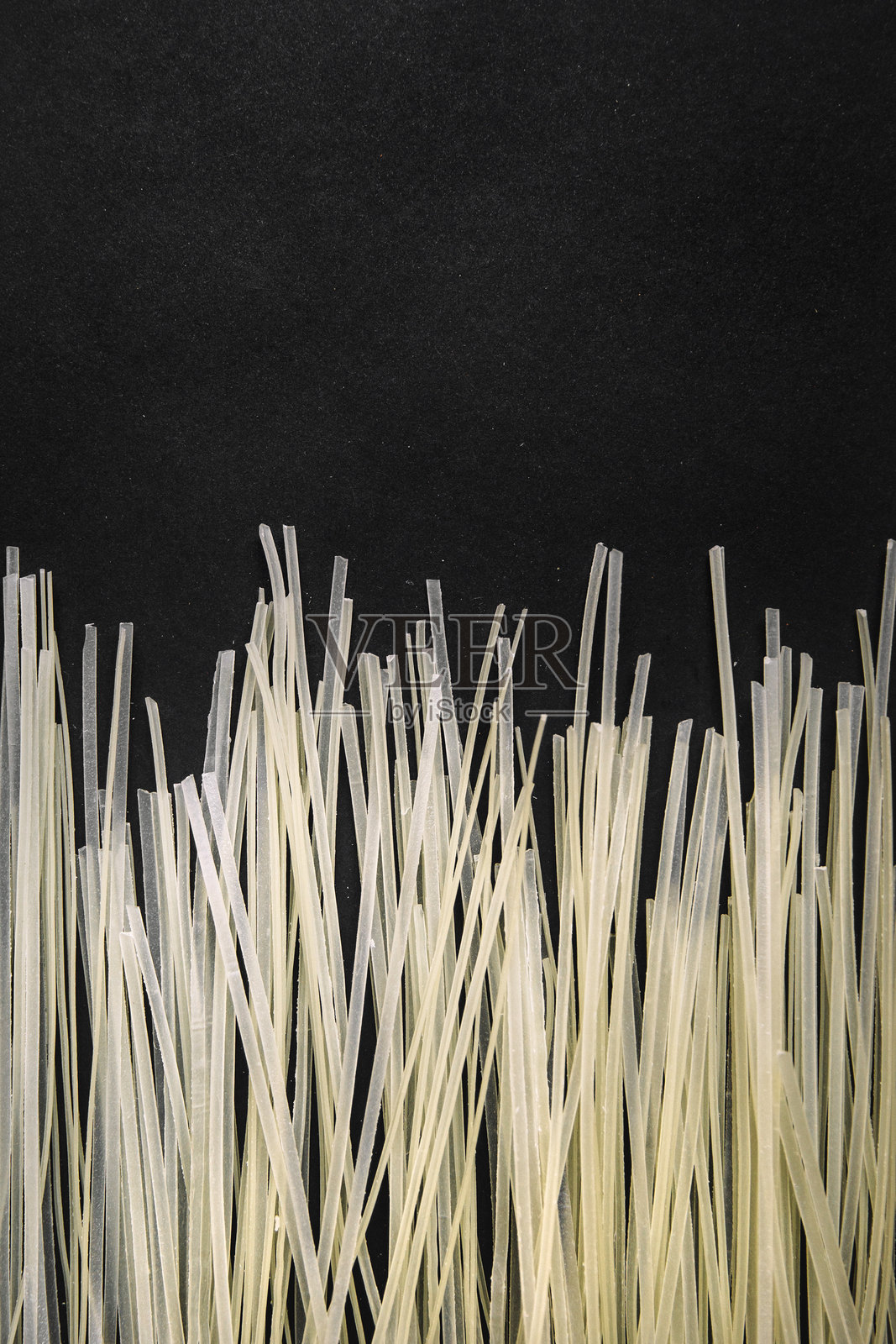 在深色背景上垂直排列的生白米粉，突显其细腻的质感，强调食品摄影中的简约风格。照片摄影图片