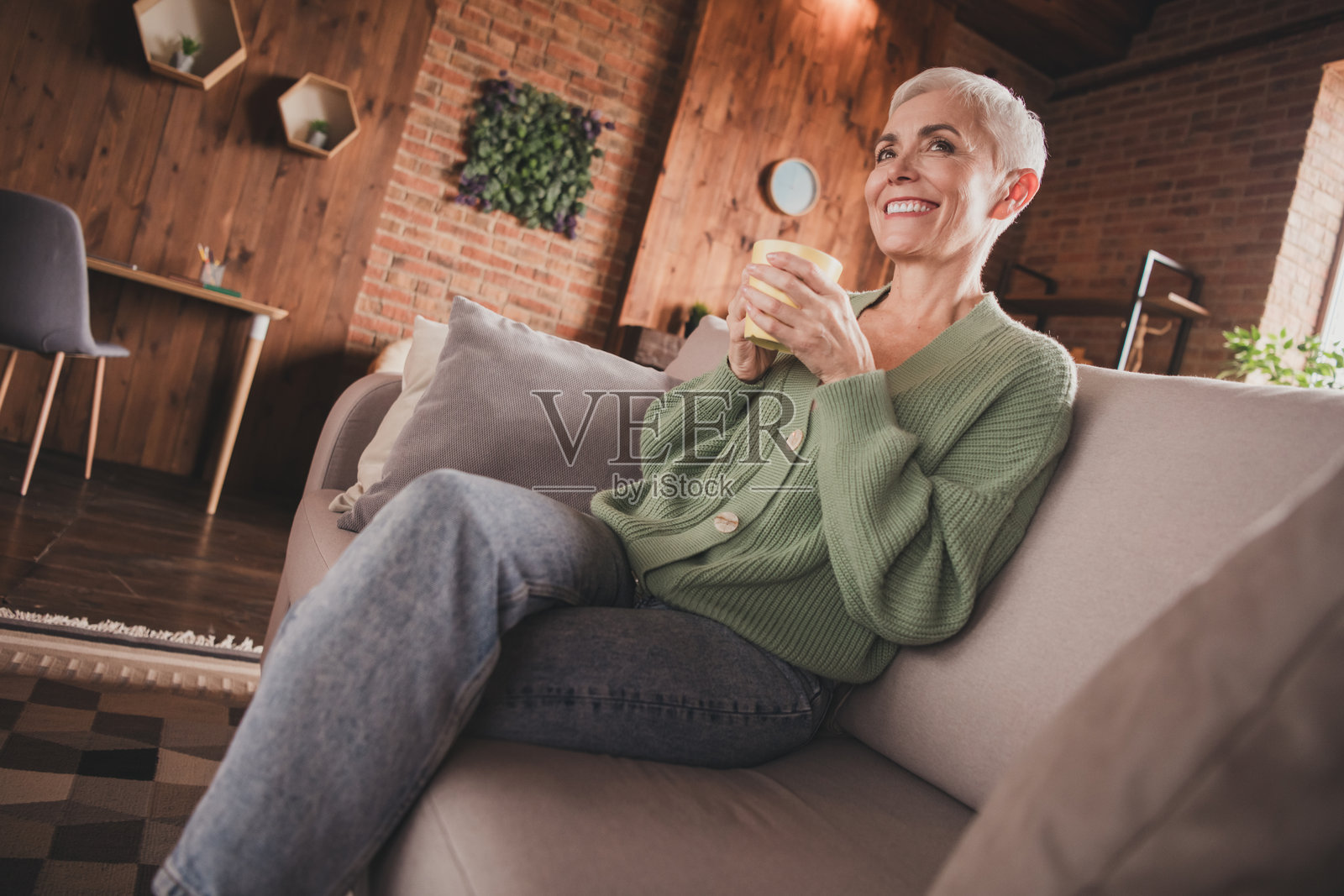 美丽的老年女性在家中享受温馨的周末，脸上挂着温暖的微笑照片摄影图片