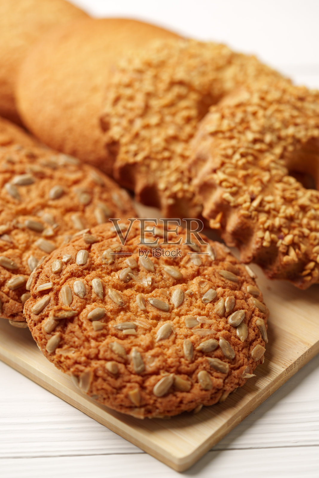 新鲜出炉的饼干摆放在木板上，背景为自然光下的乡村风格。照片摄影图片