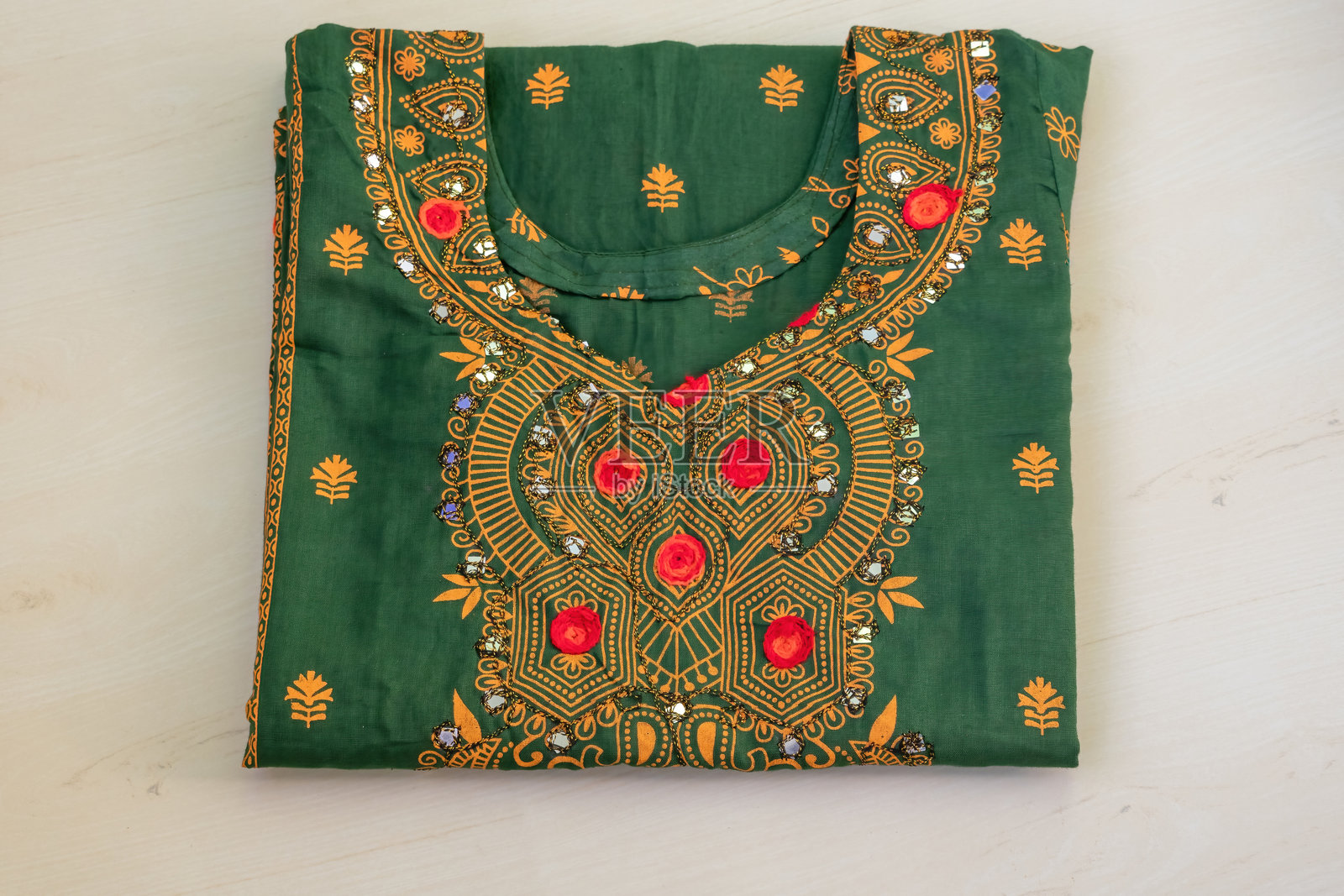 绿色印花女装（3件）叠放在木质背景上。照片摄影图片