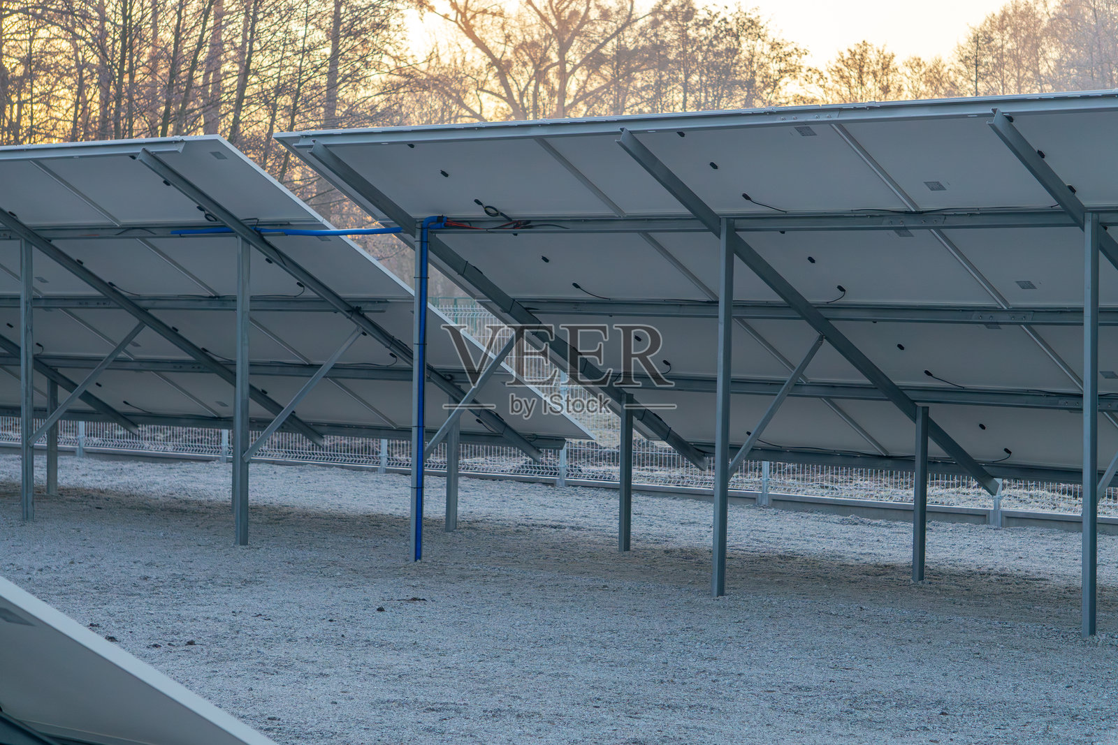 冬季日出时湖面上的城市太阳能光伏板。寒冷的冬季早晨。可再生能源，生态电力生产。照片摄影图片