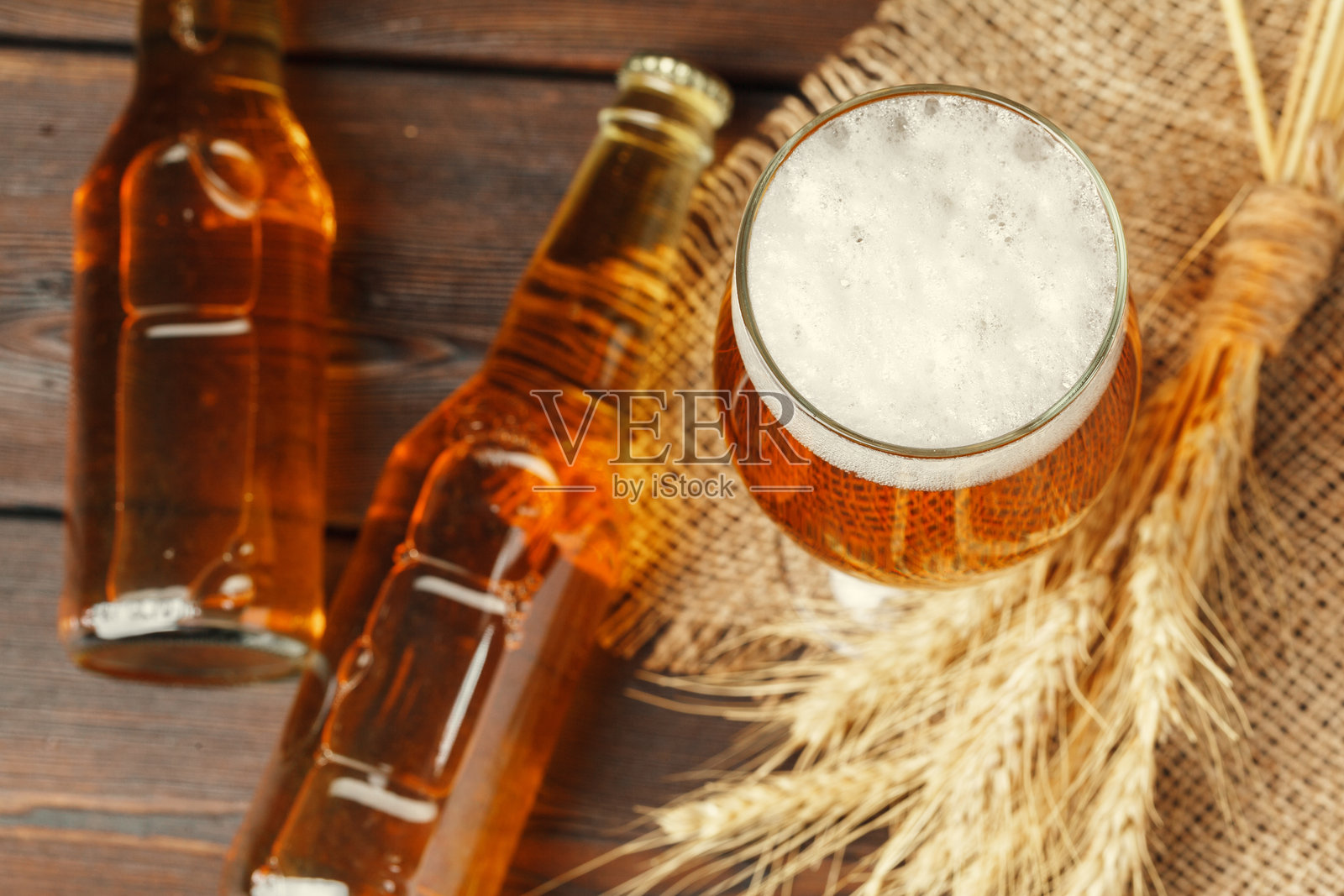 木质背景上的玻璃啤酒。创意照片。照片摄影图片