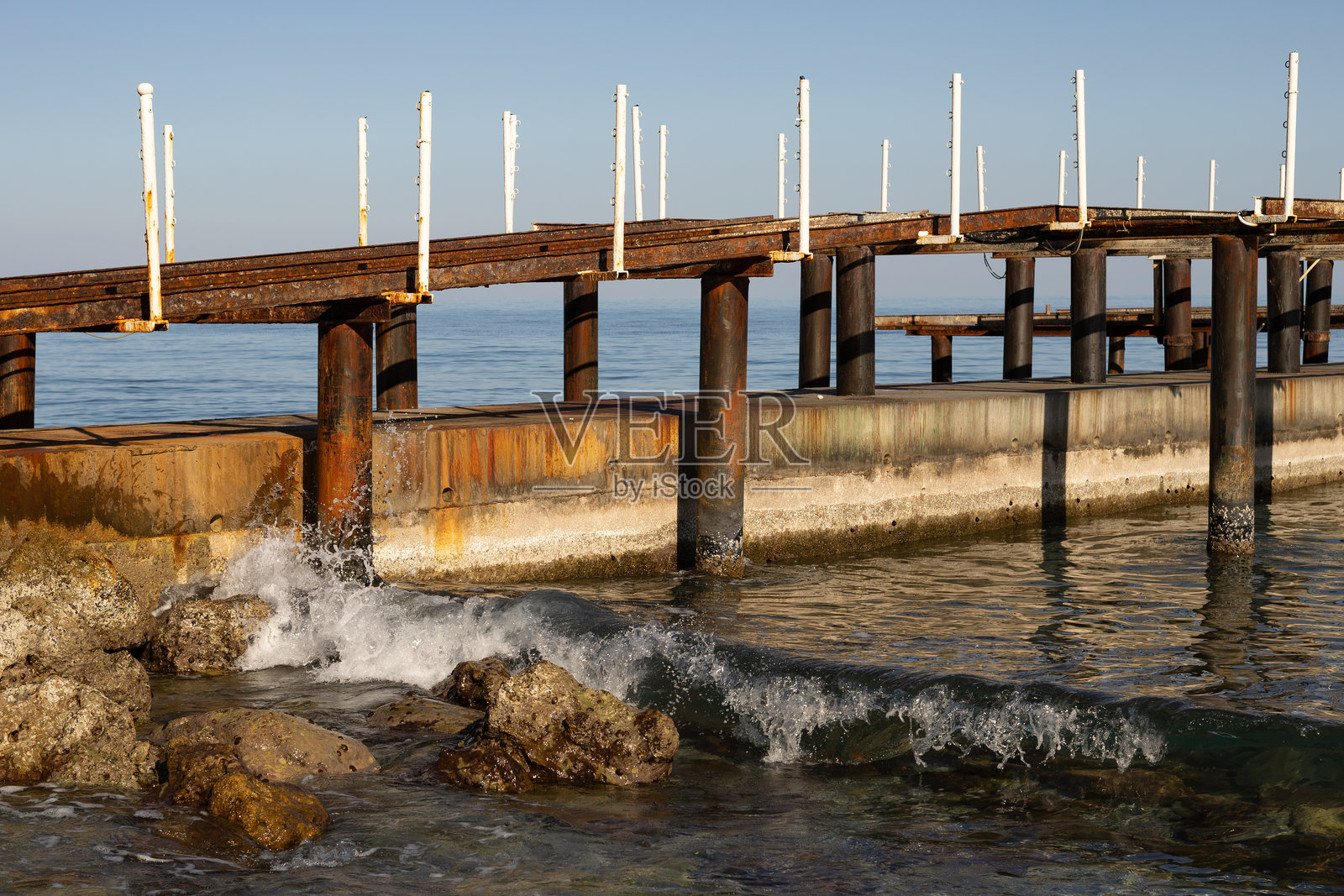 阳光明媚的日子里，地中海土耳其的旧木栈桥上有一个救生圈漂浮在海面上。照片摄影图片