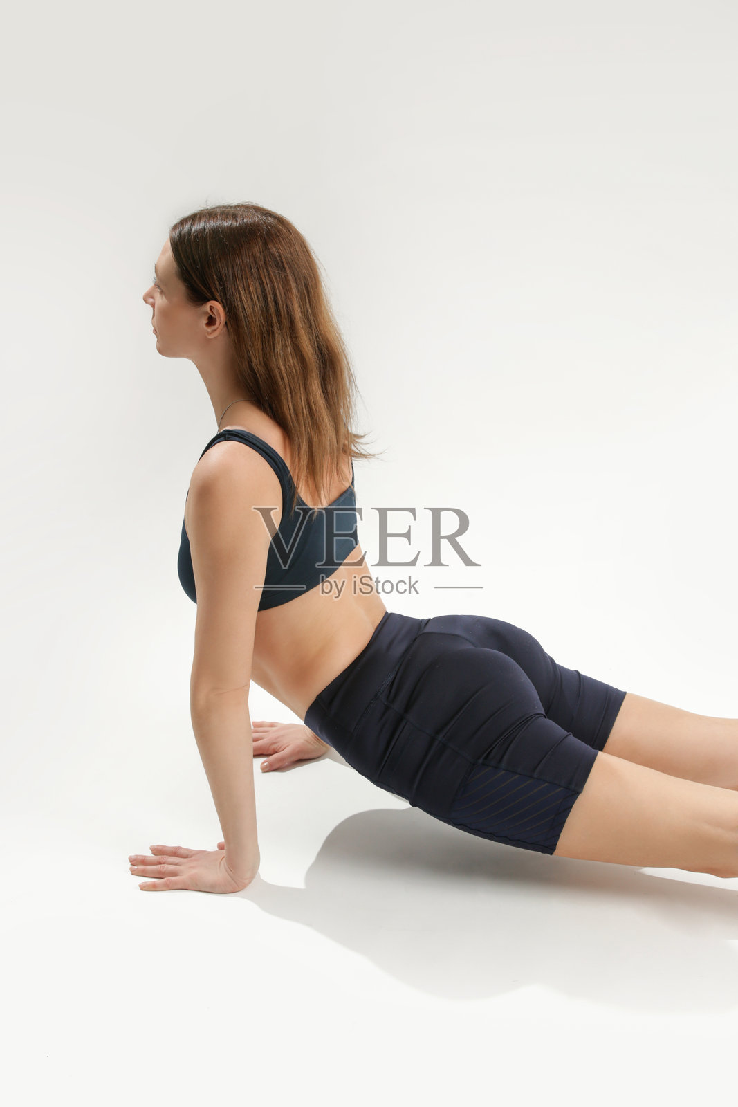 年轻女性练习拉伸瑜伽姿势，关注身心健康和自我照顾理念照片摄影图片