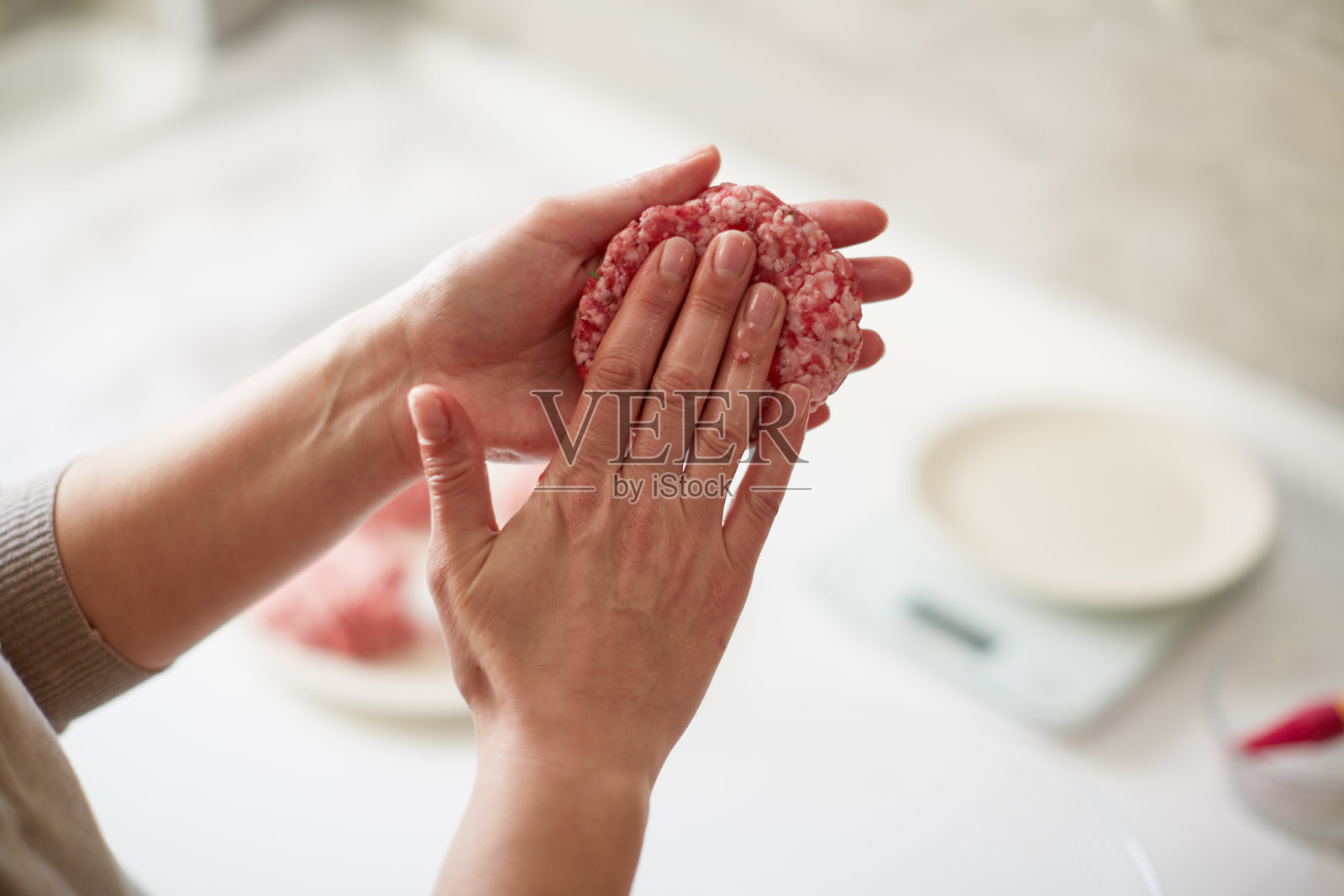 手工制作汉堡，生肉剁碎后塑形。自制新鲜的汉堡肉饼照片摄影图片