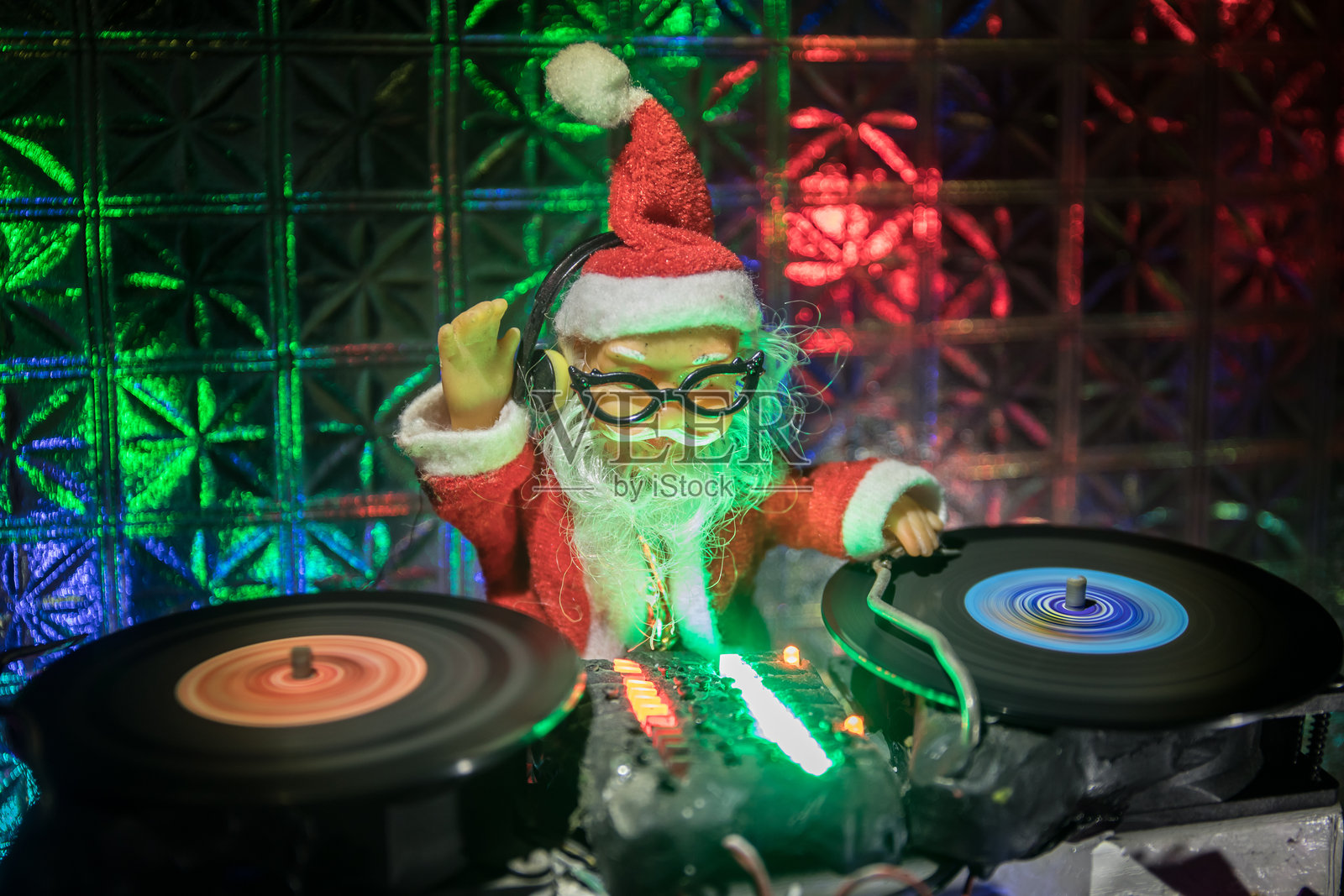 圣诞节和新年俱乐部概念。雪地上的DJ混音器和耳机。圣诞老人正在调音台上混音。创意微型模型。照片摄影图片