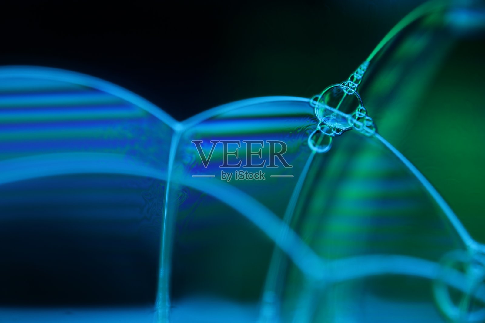 黑色背景上的蓝绿色液体反射，液体抽象，色彩波浪，深邃的黑暗背景照片摄影图片