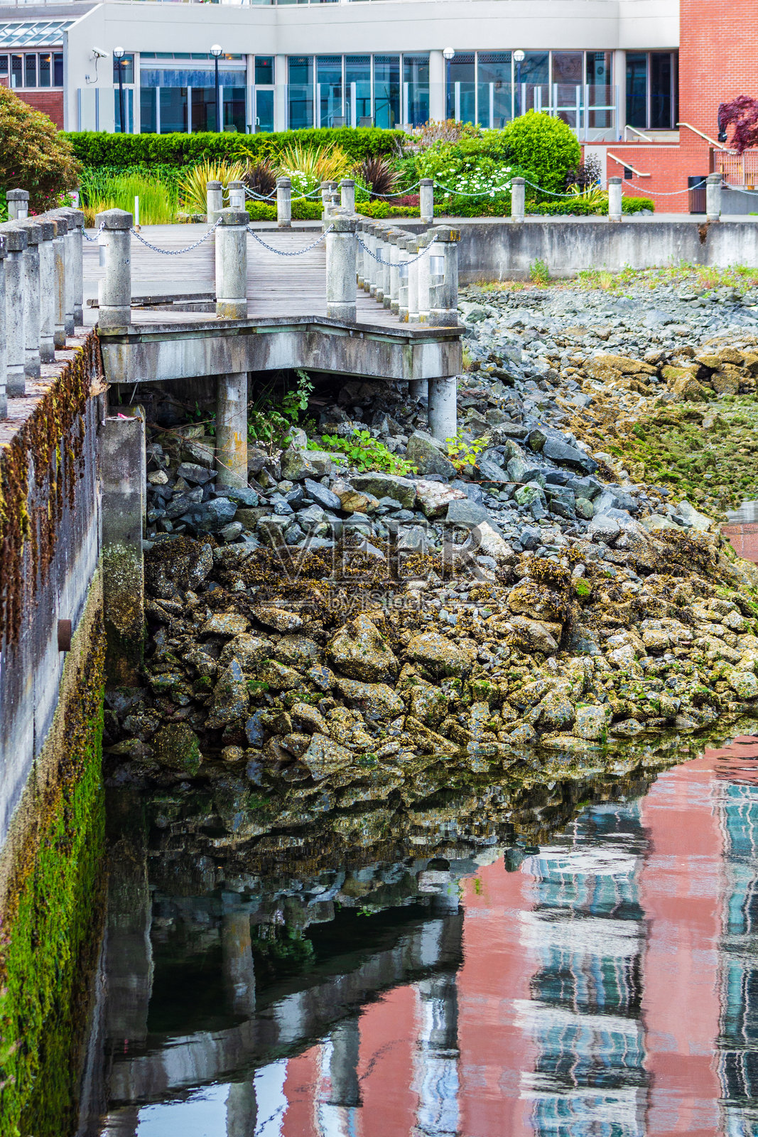 水边步道与砖砌建筑倒影场景照片摄影图片