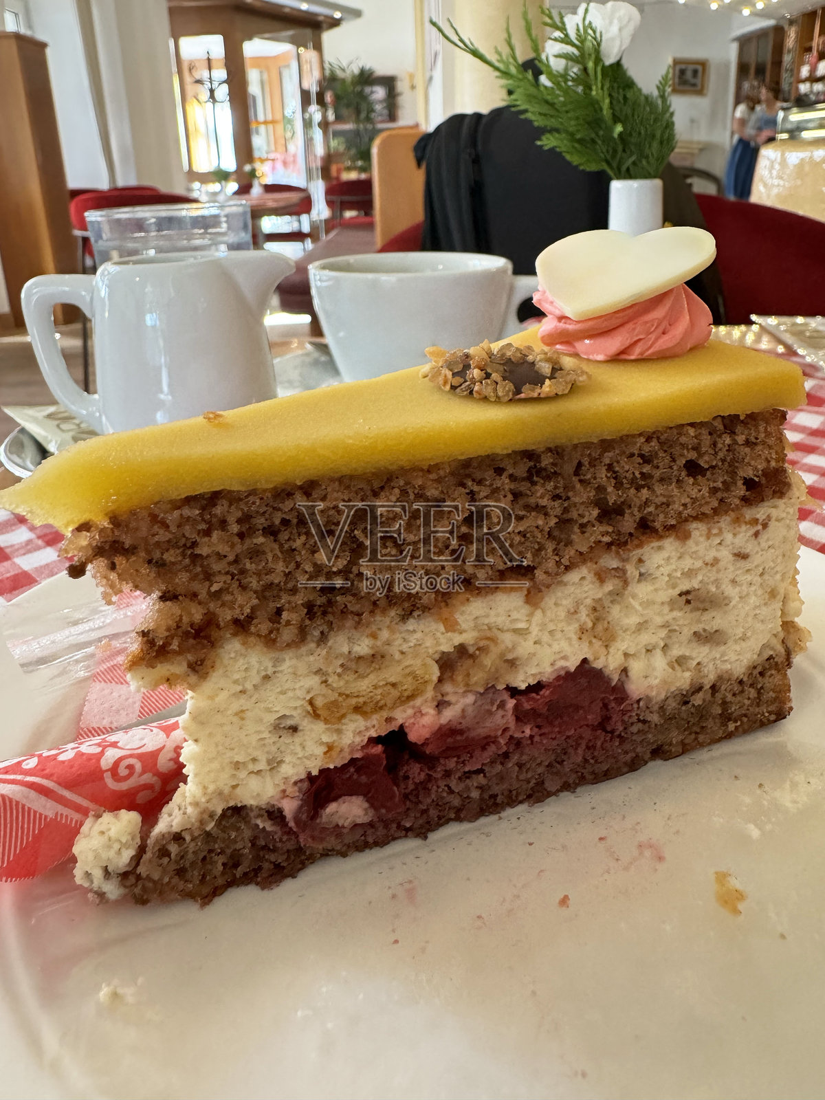 美味的分层蛋糕，配有杏仁糖和鲜奶油，置于咖啡馆环境中照片摄影图片