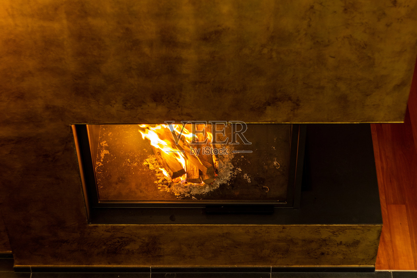 一个豪华的壁炉，温暖的火焰在舒适的客厅中噼啪作响照片摄影图片