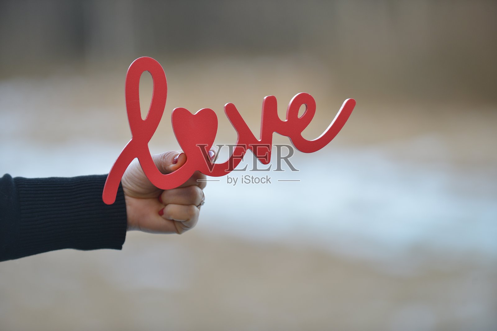 手握红色“爱”字标志照片摄影图片