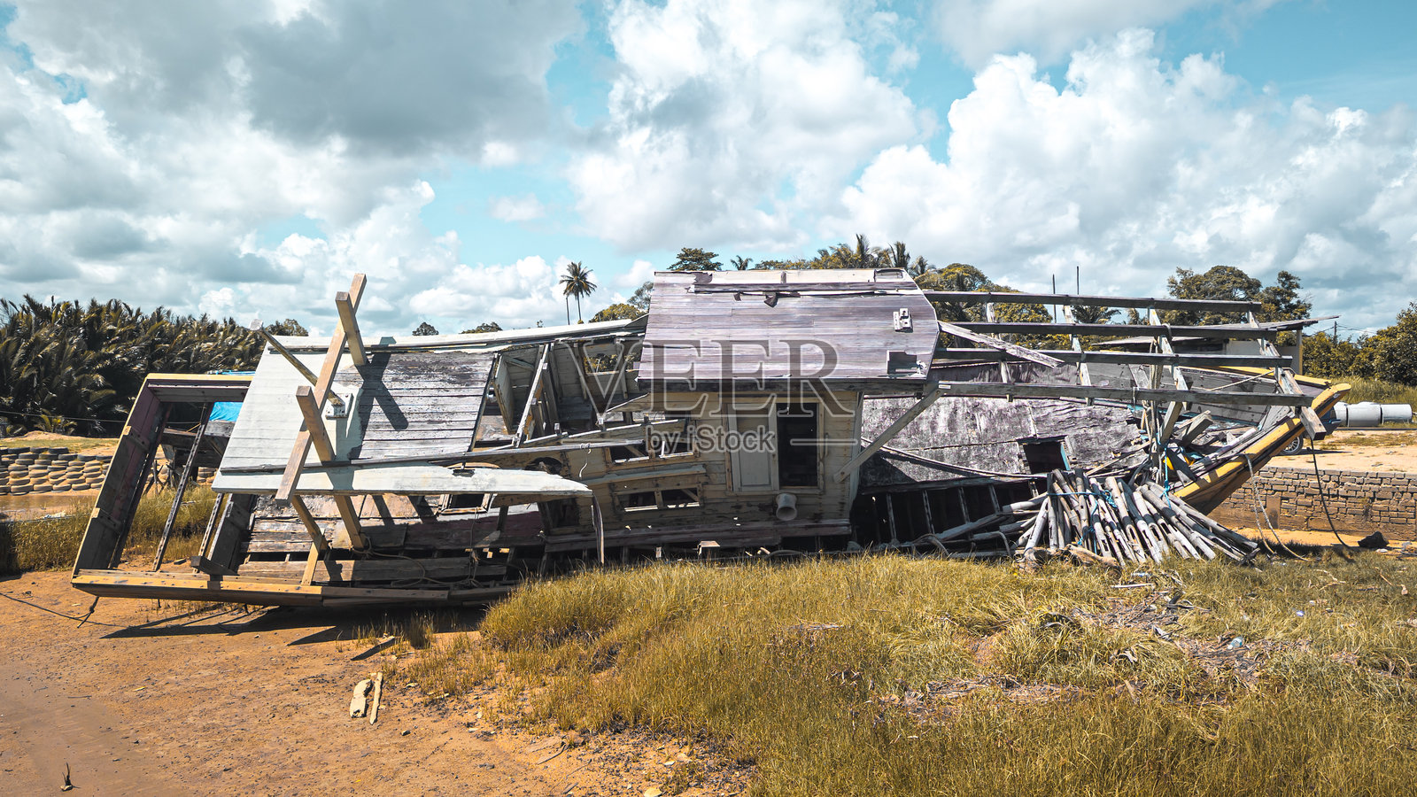 一只被毁坏并被遗弃的木船。照片摄影图片