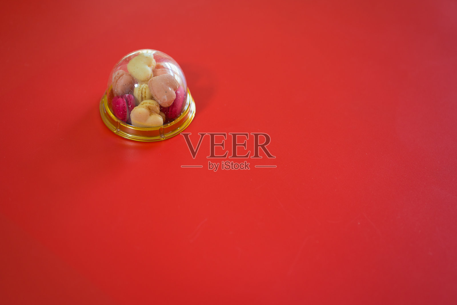 红色背景上的马卡龙心形平铺排列照片摄影图片