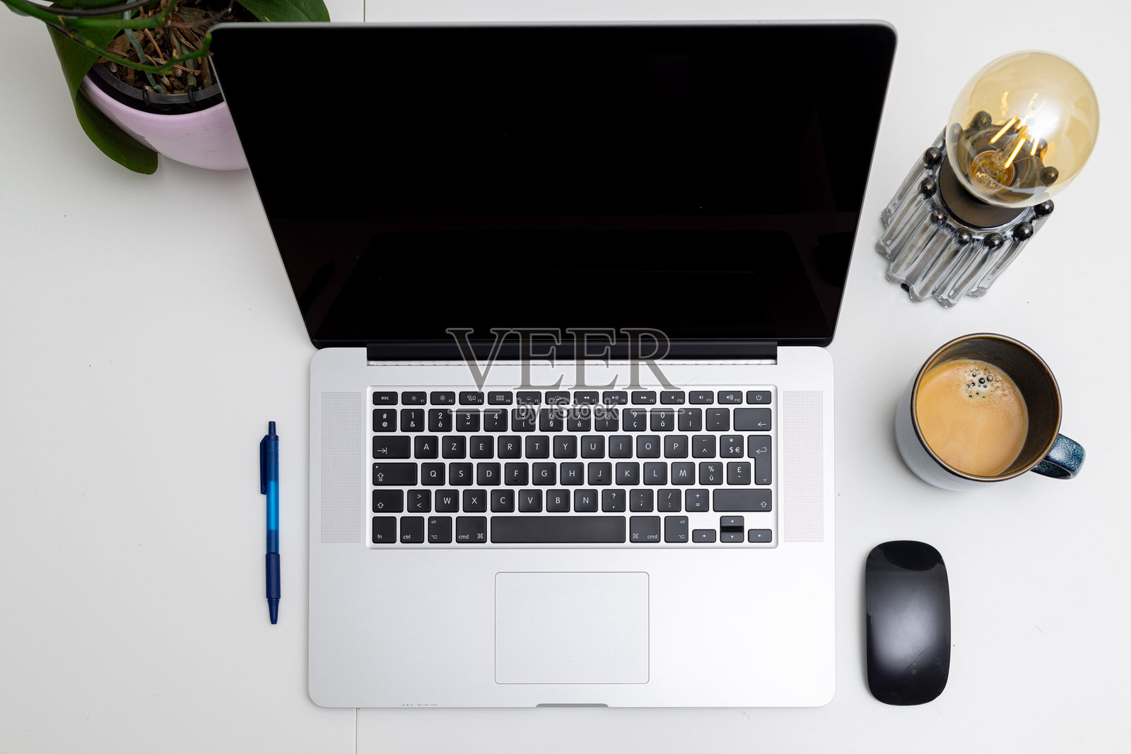 整洁的桌面上摆放着笔记本电脑、咖啡杯、钢笔和鼠标的平铺图。照片摄影图片