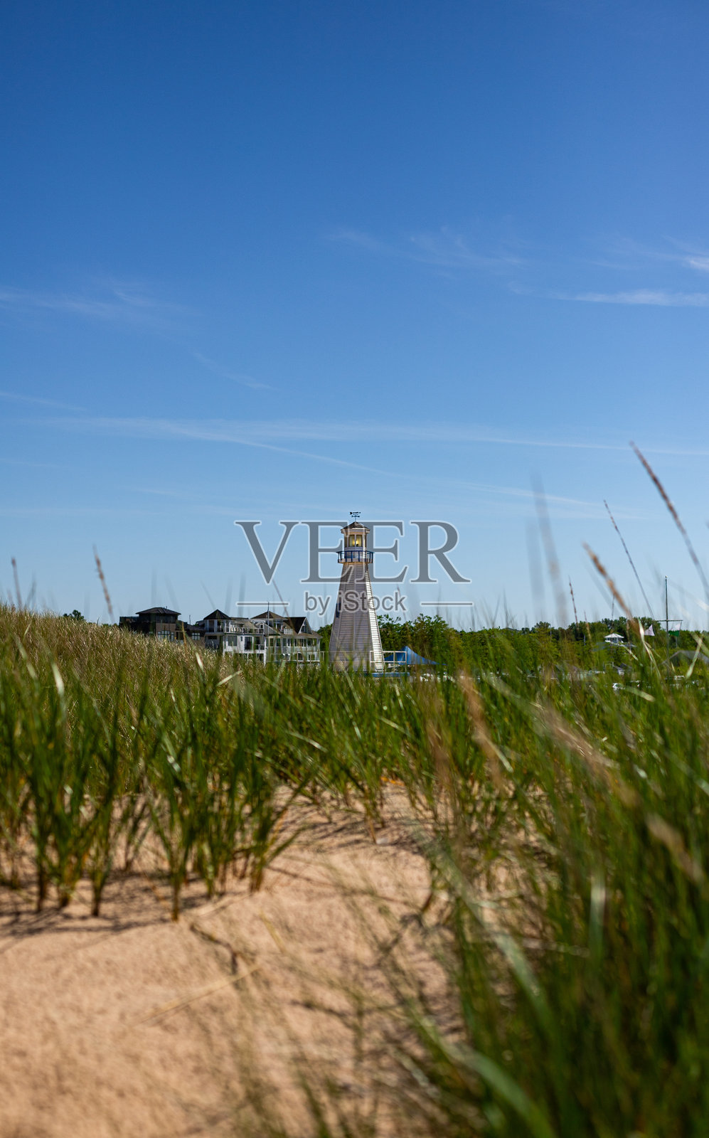 阳光明媚的海边灯塔。孤立的白色灯塔照片摄影图片